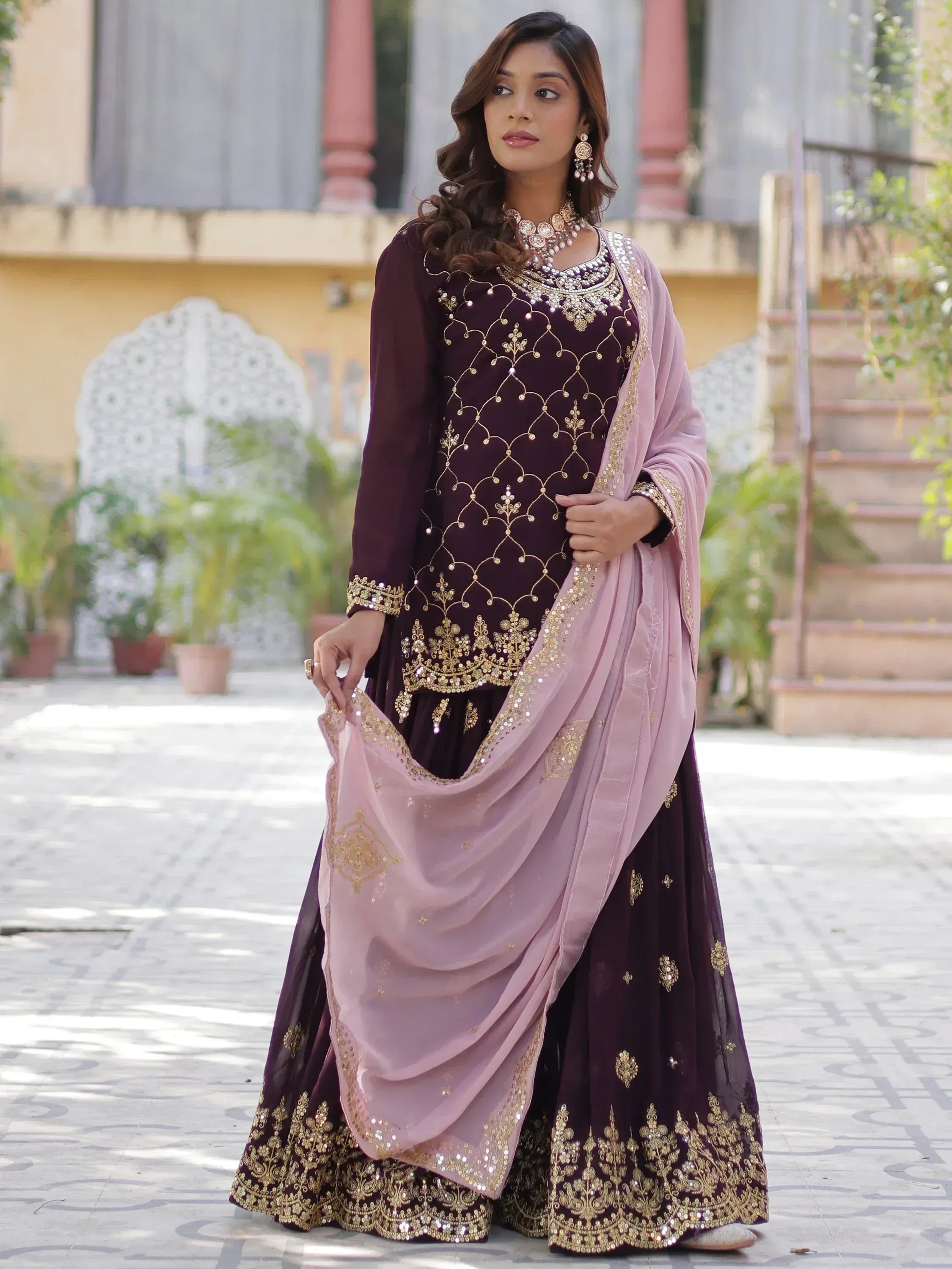 Elegant purple Indian ethnic wear with gold embroidery and pink dupatta, perfect for festive occasions.