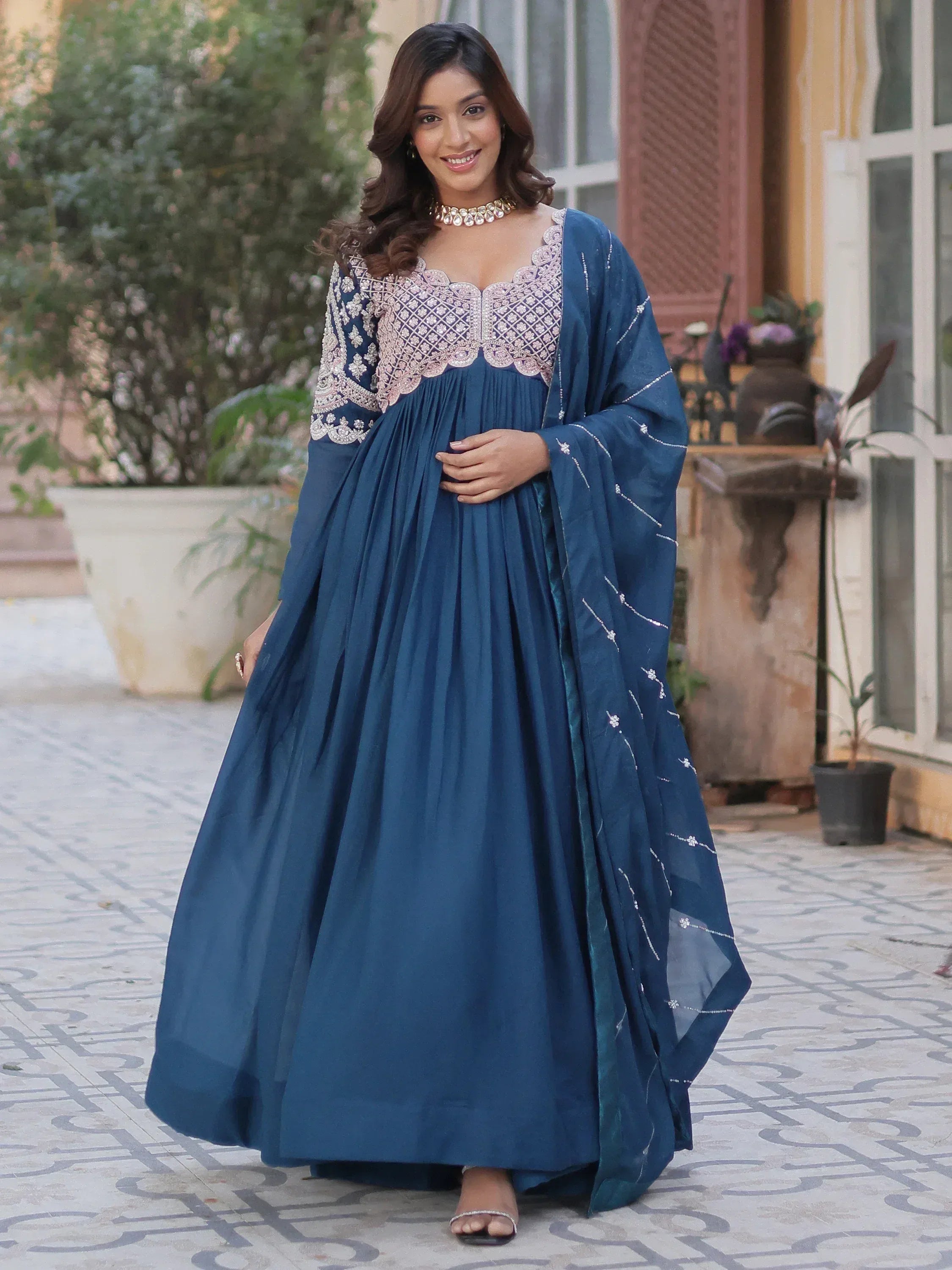 Woman in elegant blue ethnic gown with intricate embroidery, perfect for Indian occasions and festive wear.