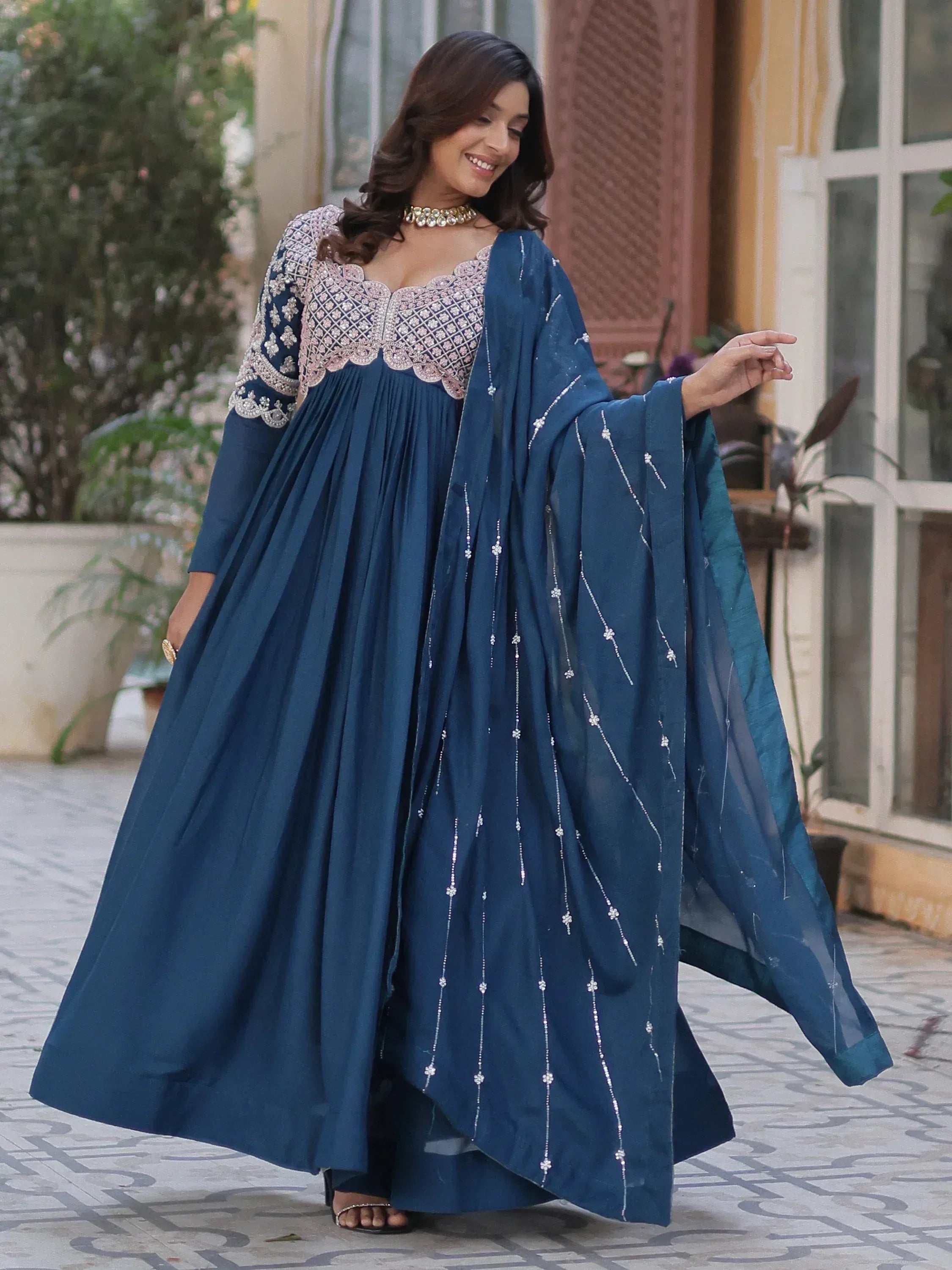Elegant blue ethnic gown with intricate embroidery and scalloped neckline, perfect for Indian occasions.