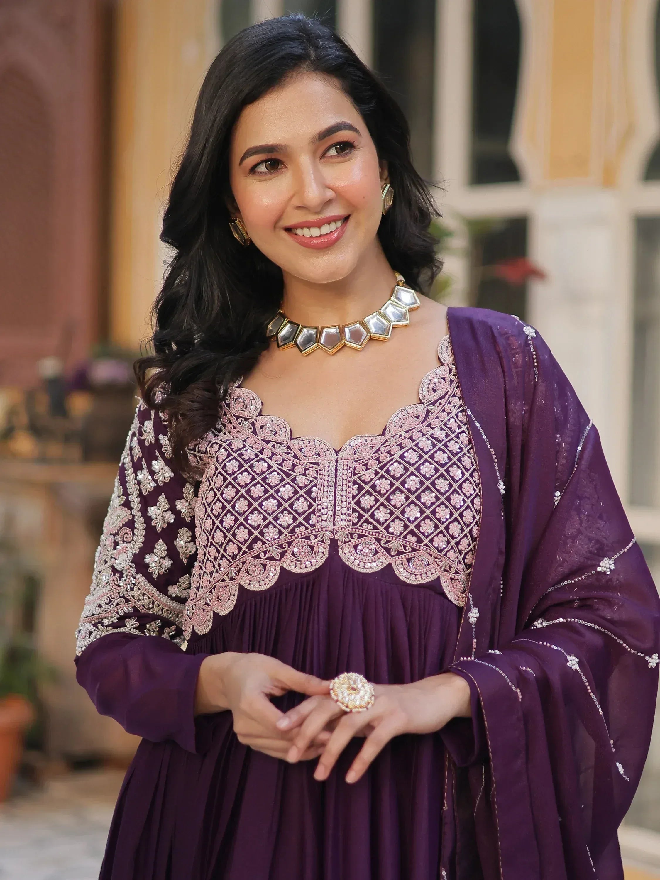 Woman in purple embroidered ethnic gown with mirror work, perfect for Indian occasions