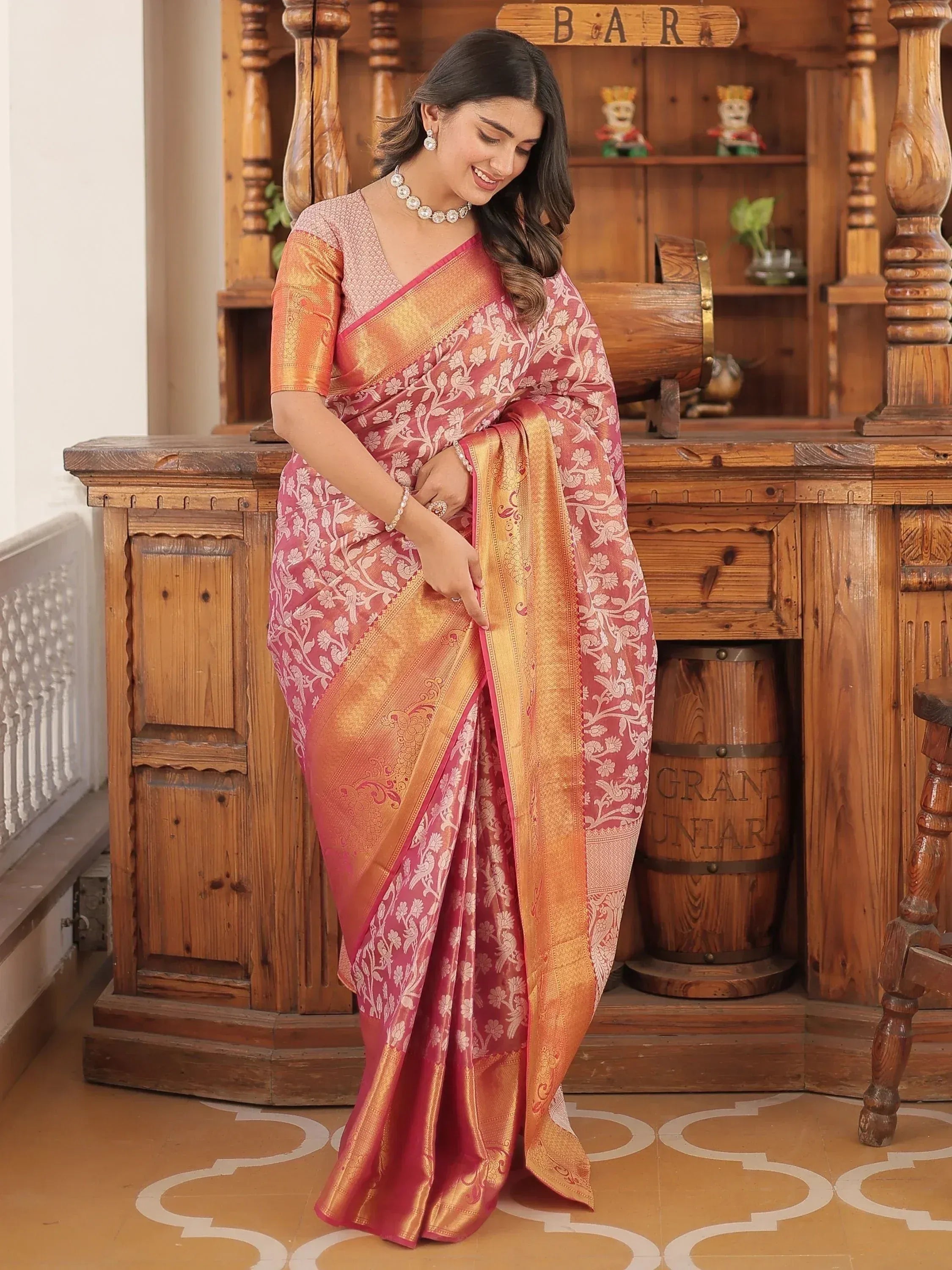 Pink and gold floral designer saree with woven border, perfect for ethnic occasions