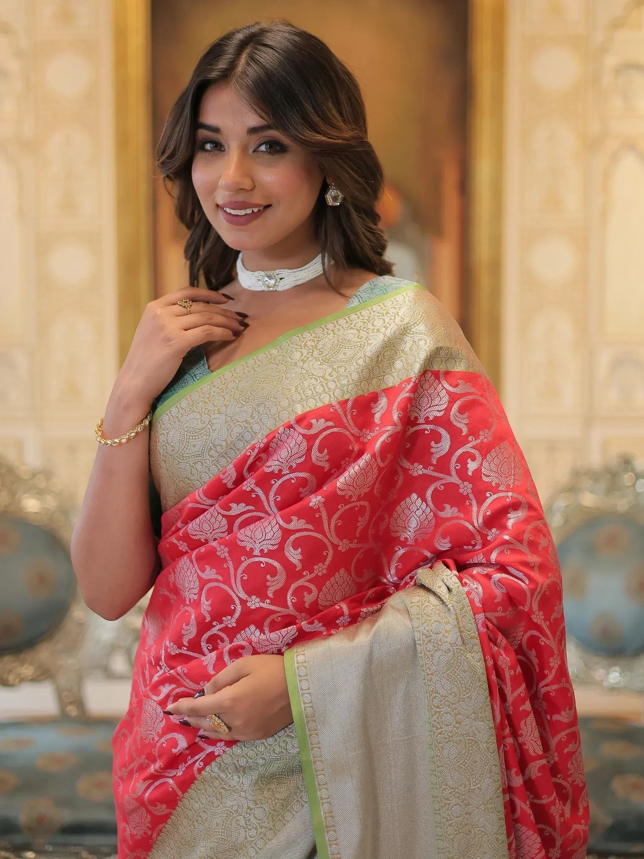 Woman in elegant red and gold designer saree with intricate floral patterns, perfect for Indian ethnic wear occasions