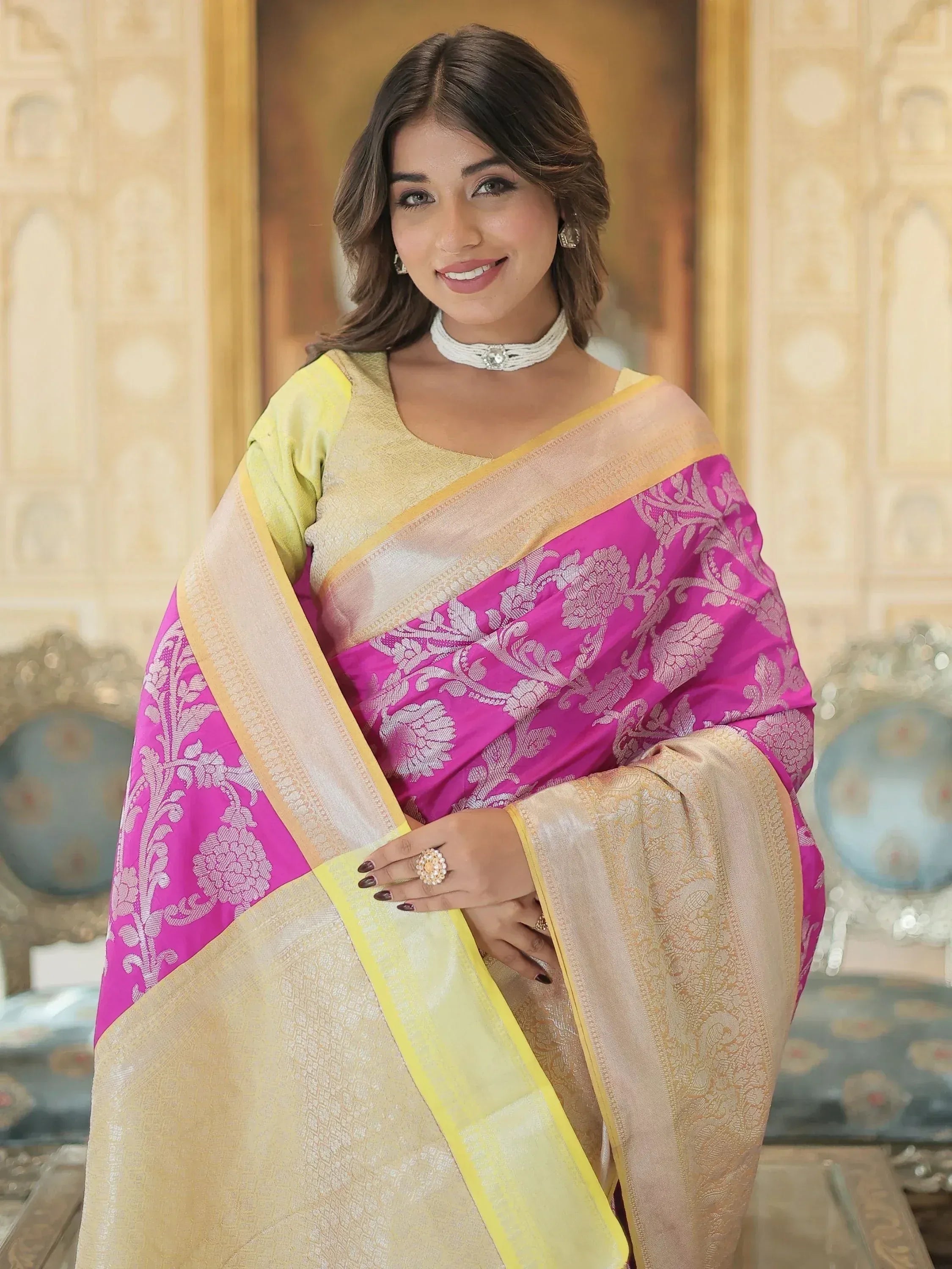 Woman in vibrant pink and gold designer saree with floral motifs, perfect for Indian ethnic wear occasions.
