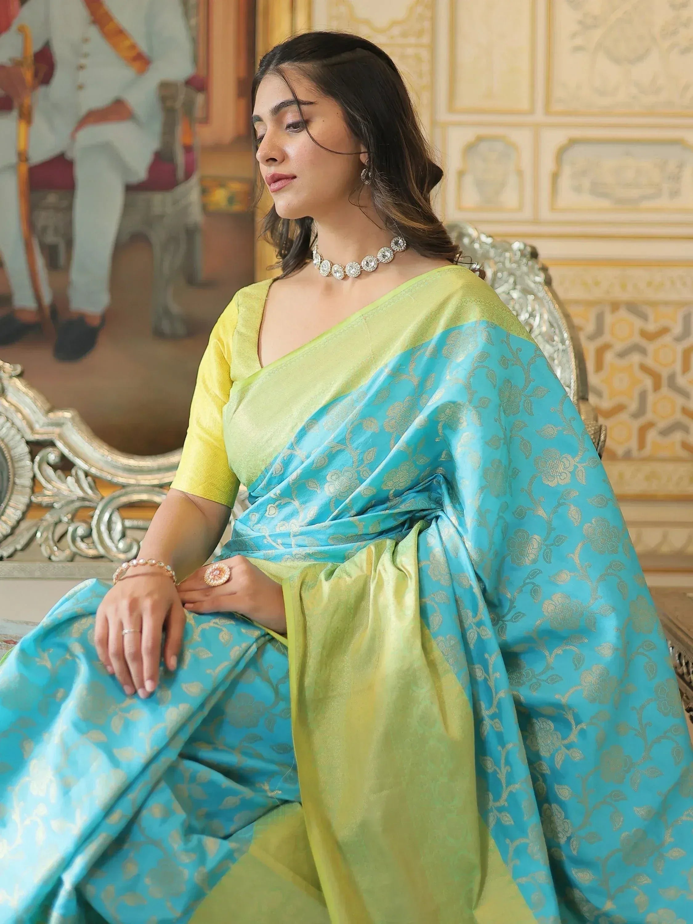 Woman in elegant blue and green designer saree with gold floral motifs, perfect for Indian ethnic wear occasions