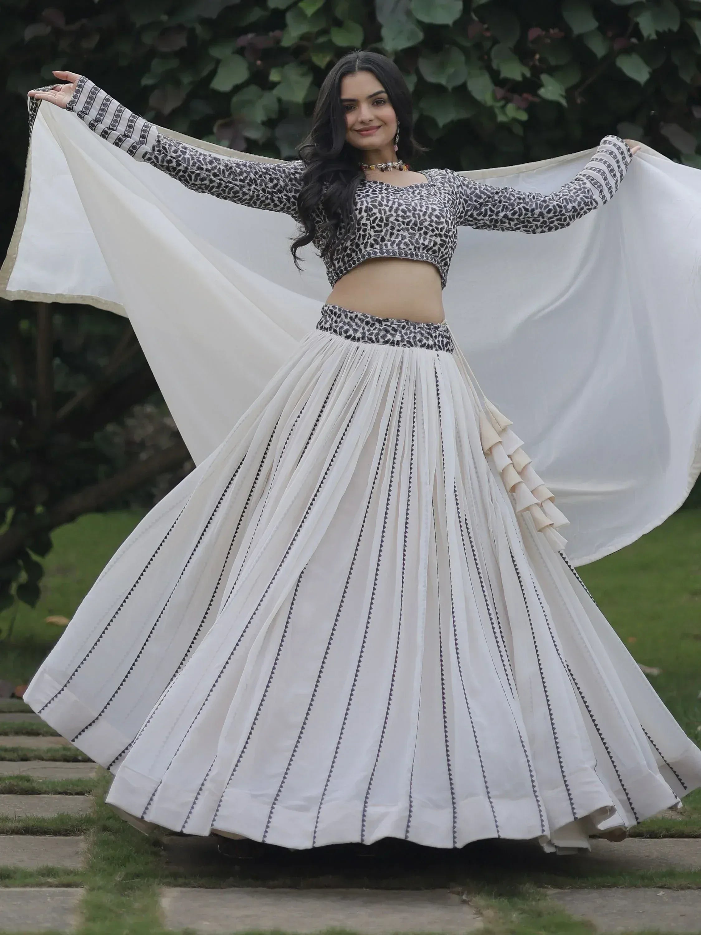 Woman in white pleated lehenga with black print crop top and dupatta, Indian ethnic wear