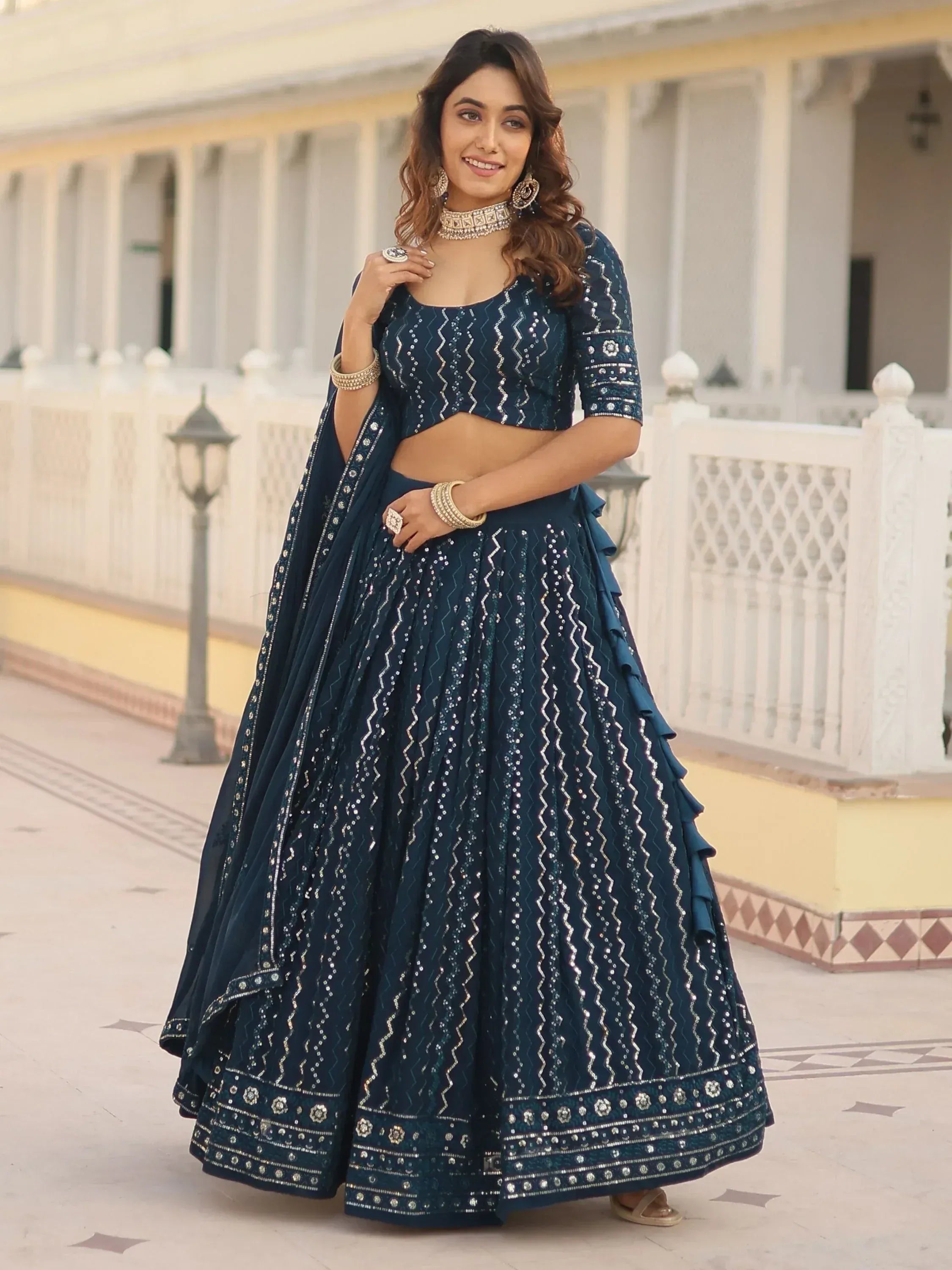Woman in navy blue designer lehenga choli with silver embroidery, perfect for Indian ethnic wear events.