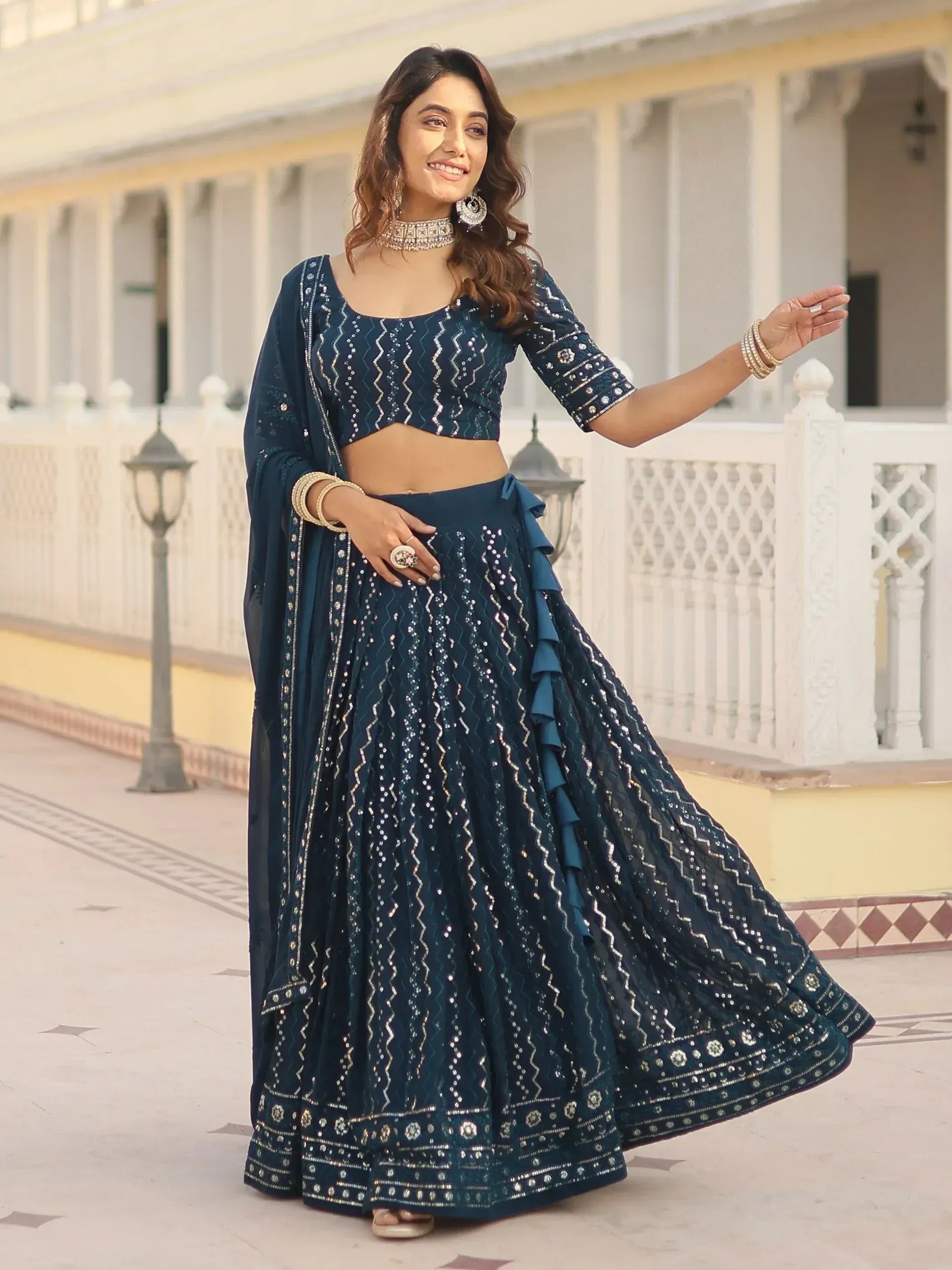 Woman in navy blue designer lehenga choli with sequin embroidery, perfect for Indian ethnic wear events