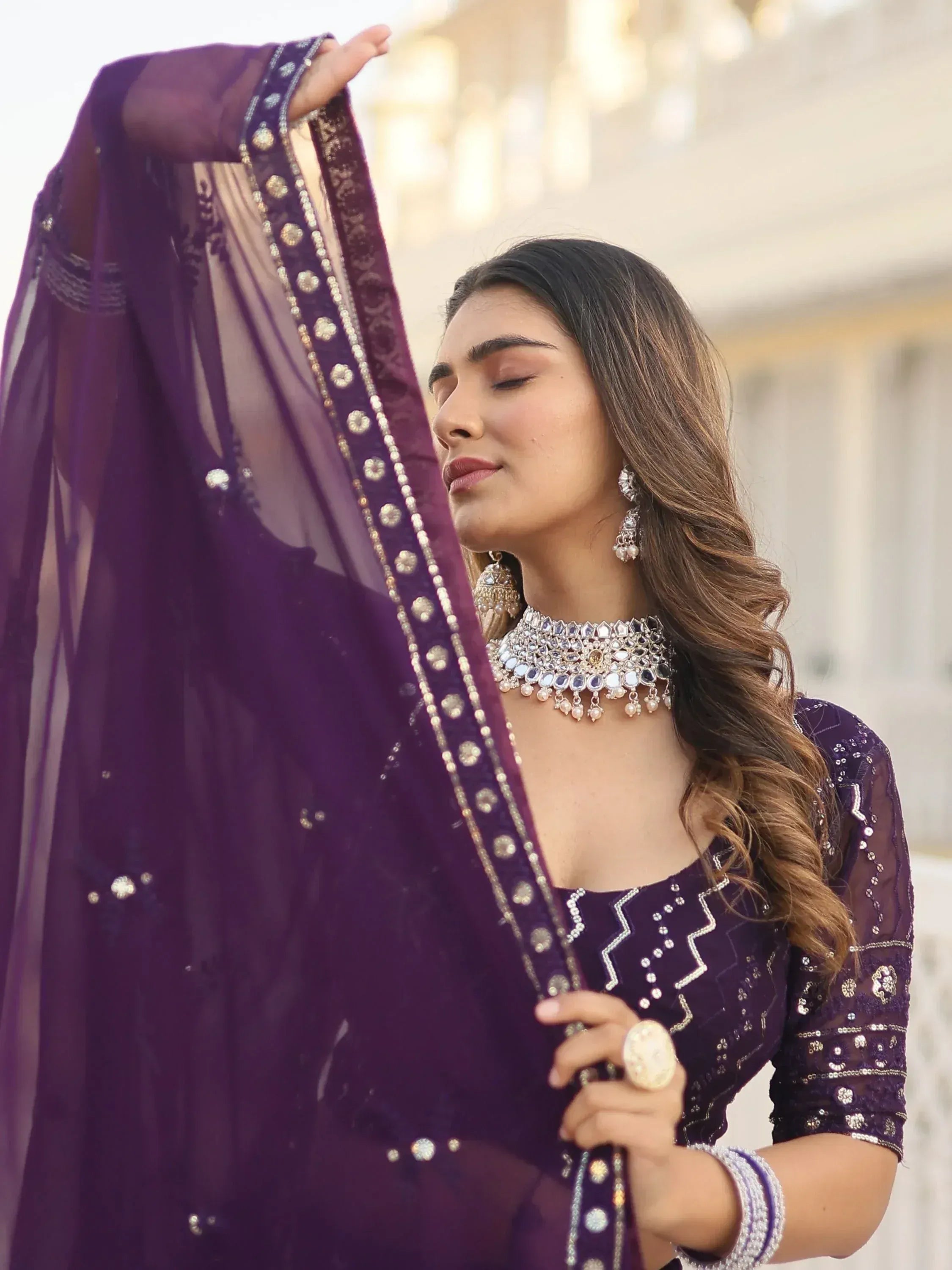 Elegant purple ethnic wear with intricate embroidery and traditional jewelry for Indian occasions
