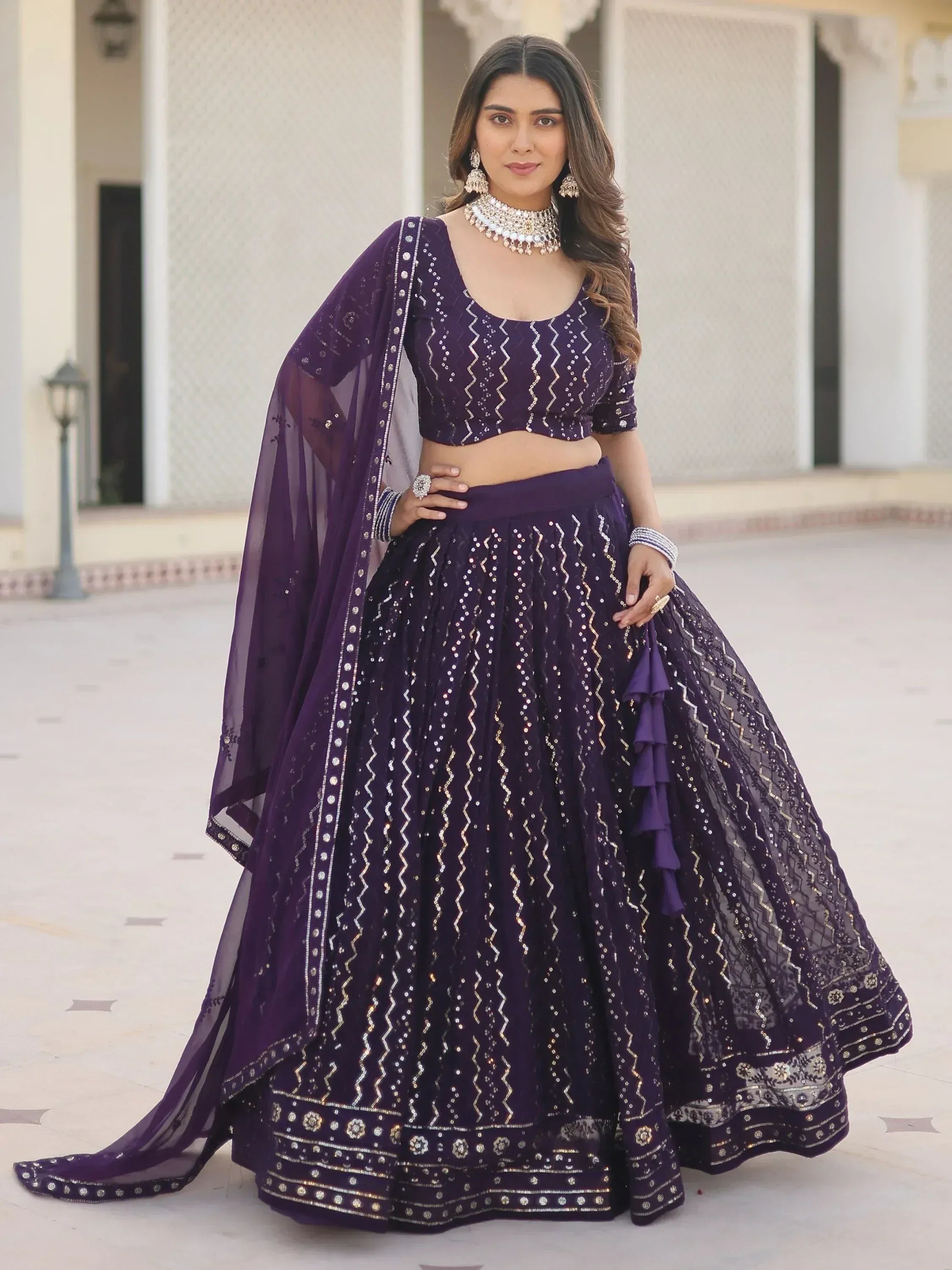 Purple designer lehenga choli with gold embroidery, perfect for Indian weddings and festive occasions.