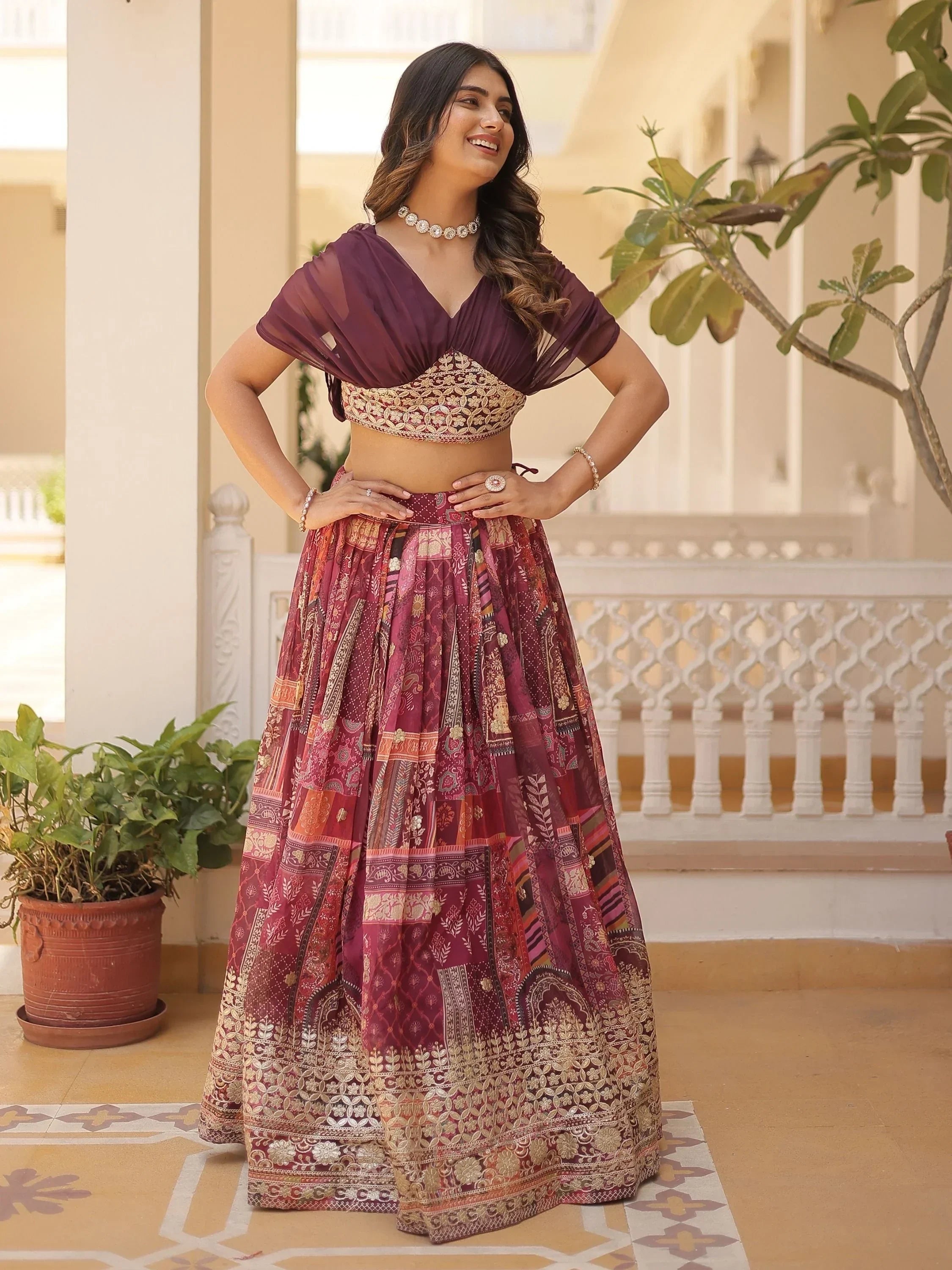 Woman in maroon embroidered lehenga choli with sheer cape, perfect for Indian ethnic wear occasions