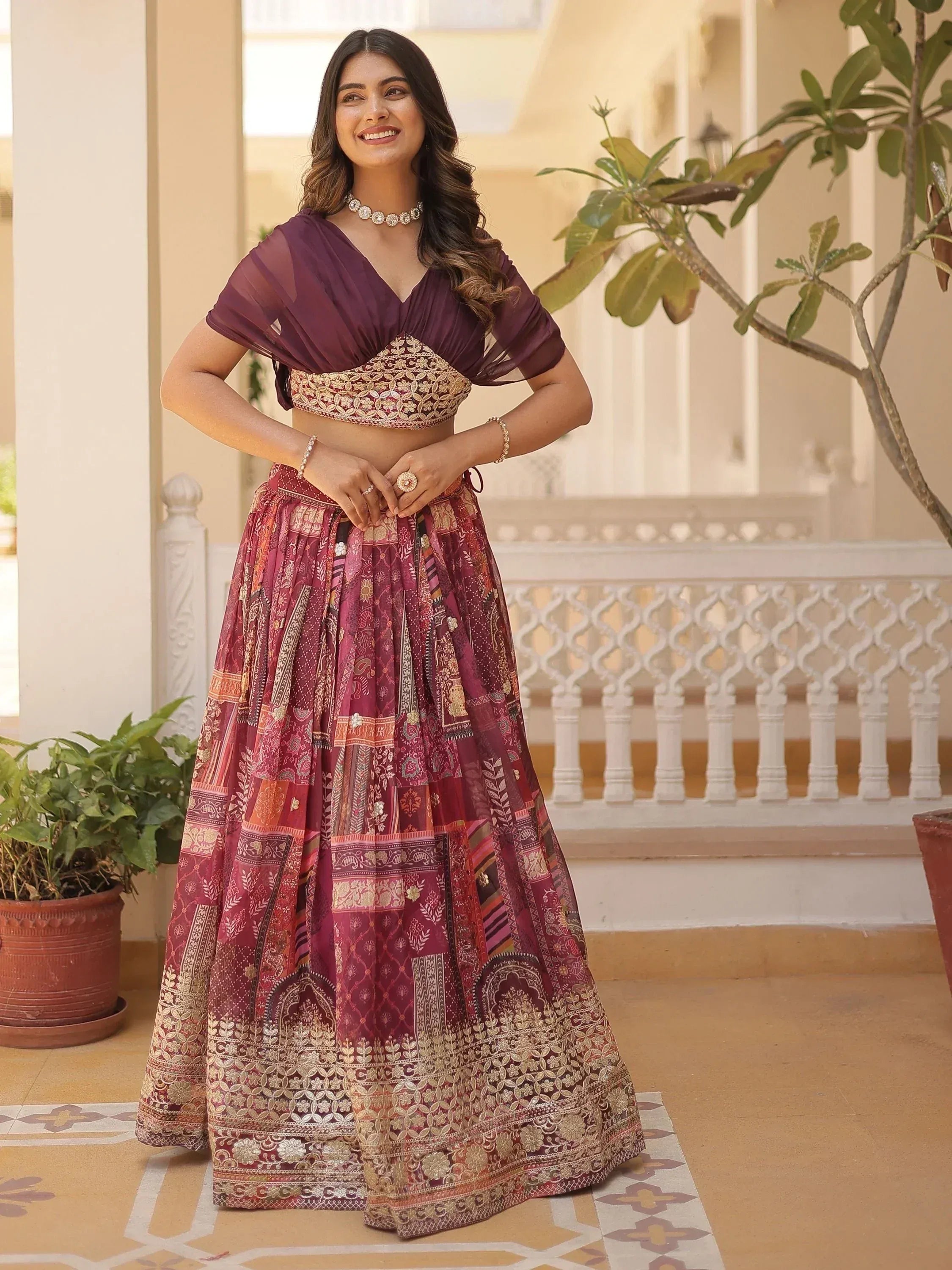 Woman in maroon embroidered lehenga choli with sheer cape, Indian ethnic wear for weddings and festivals