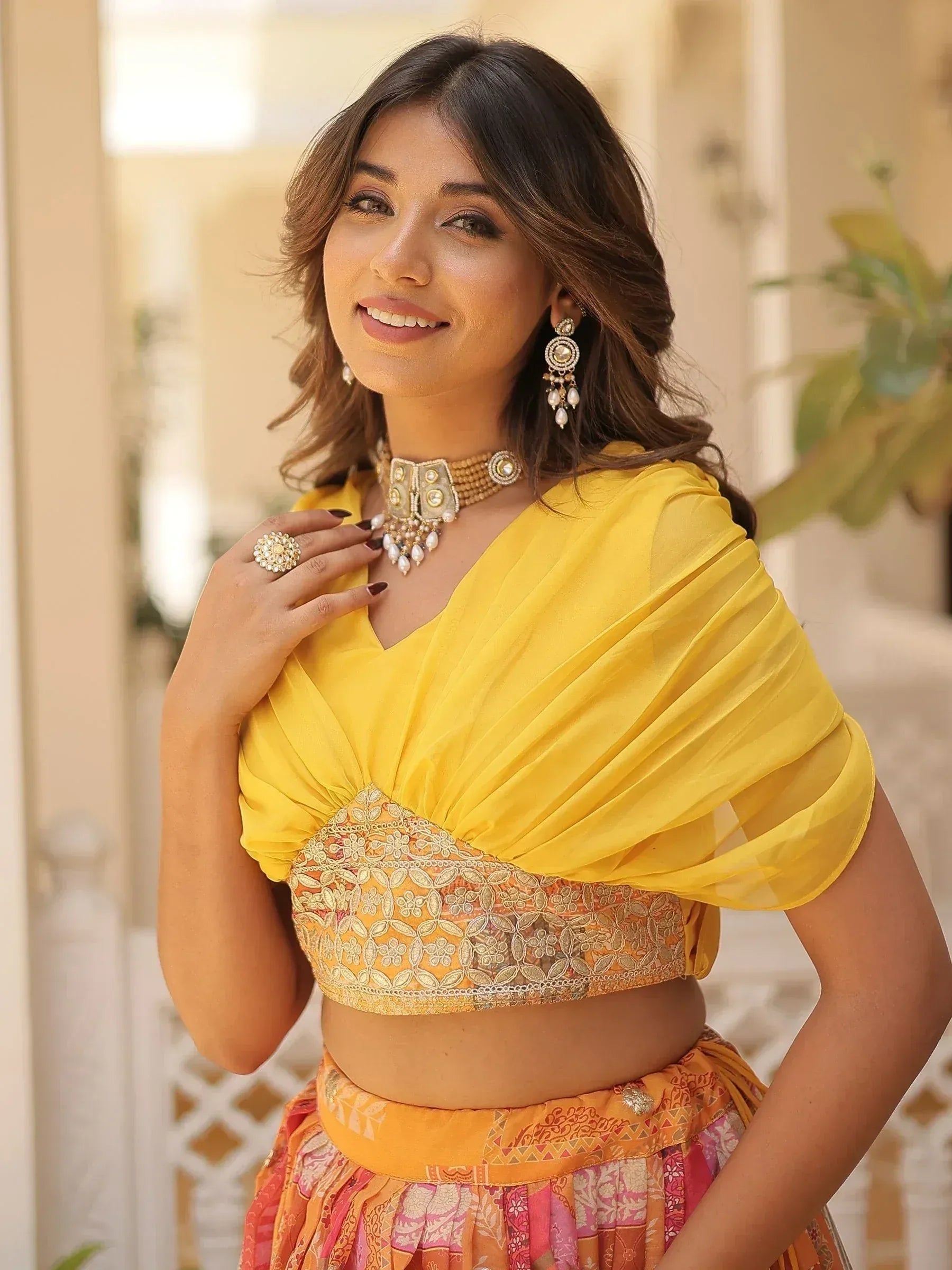 Woman in vibrant yellow ethnic lehenga choli with floral embroidery and traditional jewelry