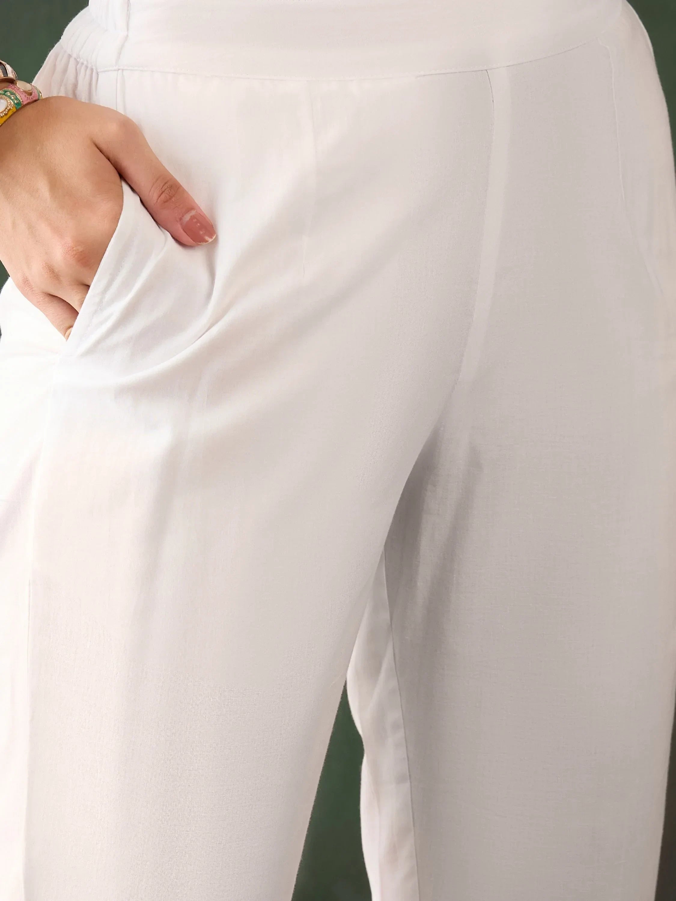 Closeup of hand in pocket of white ethnic women's straight pants