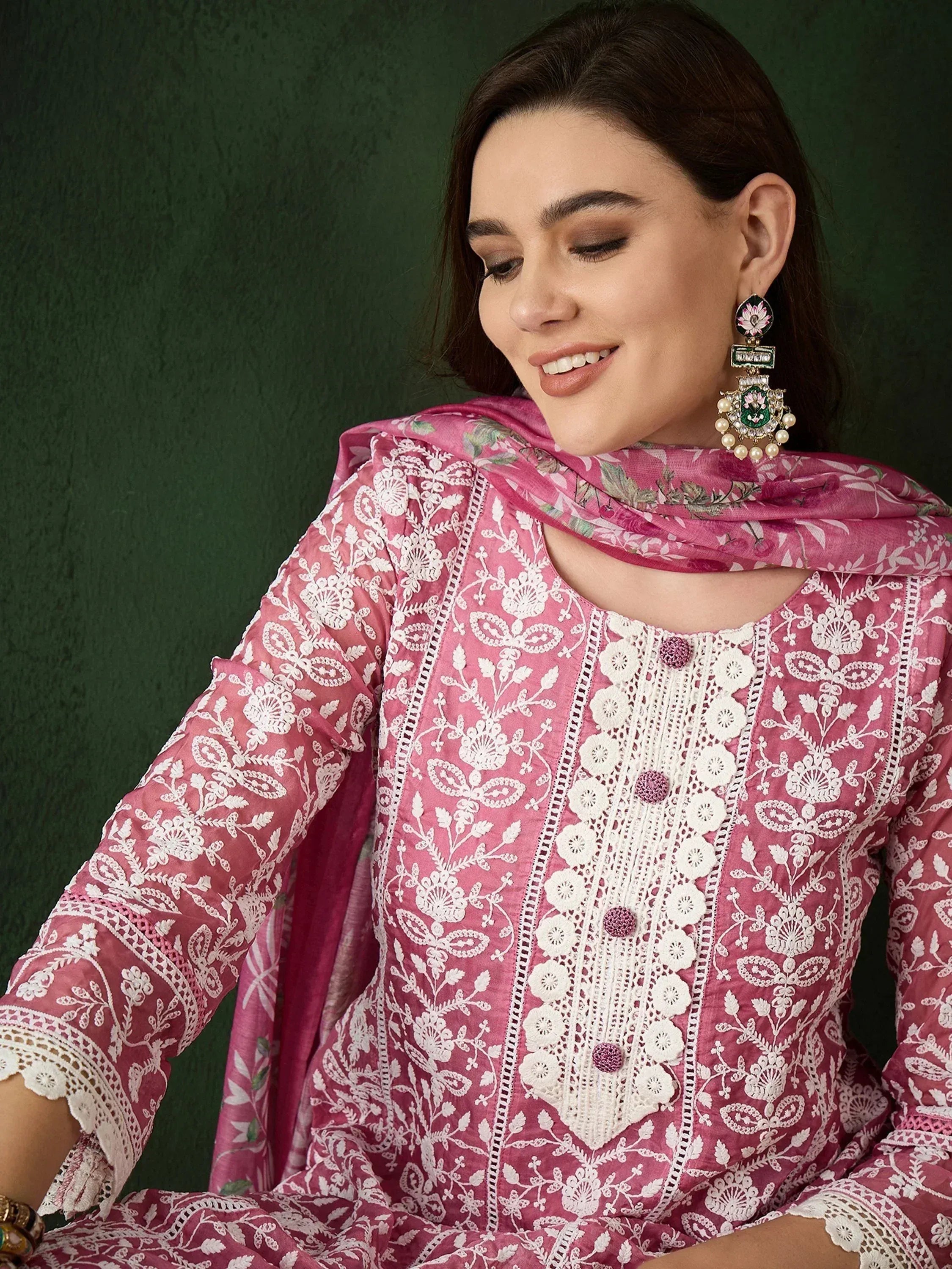 Pink embroidered salwar kameez with white floral work and matching dupatta, styled with statement earrings