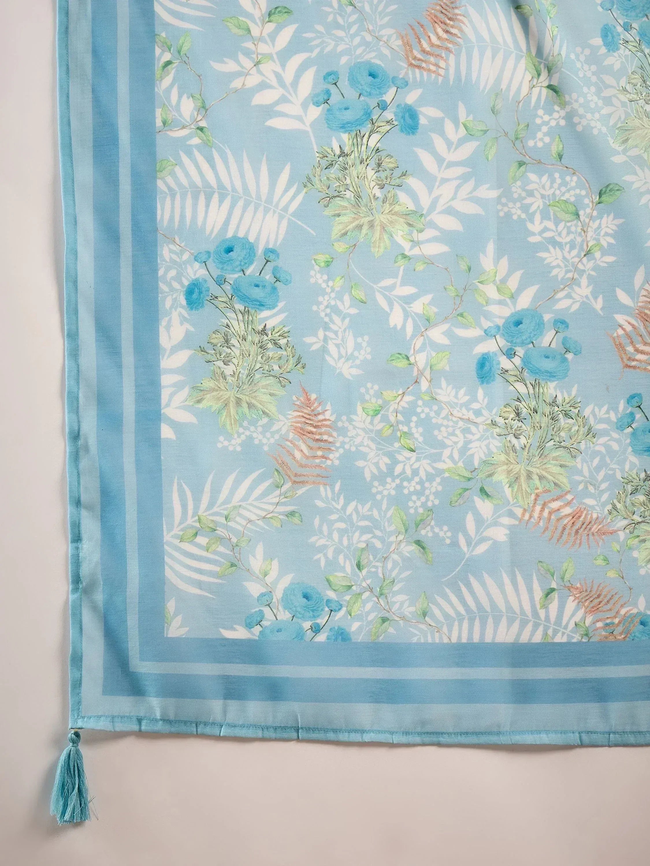 Light blue floral dupatta with green leaves, white patterns, and tassels for ethnic wear