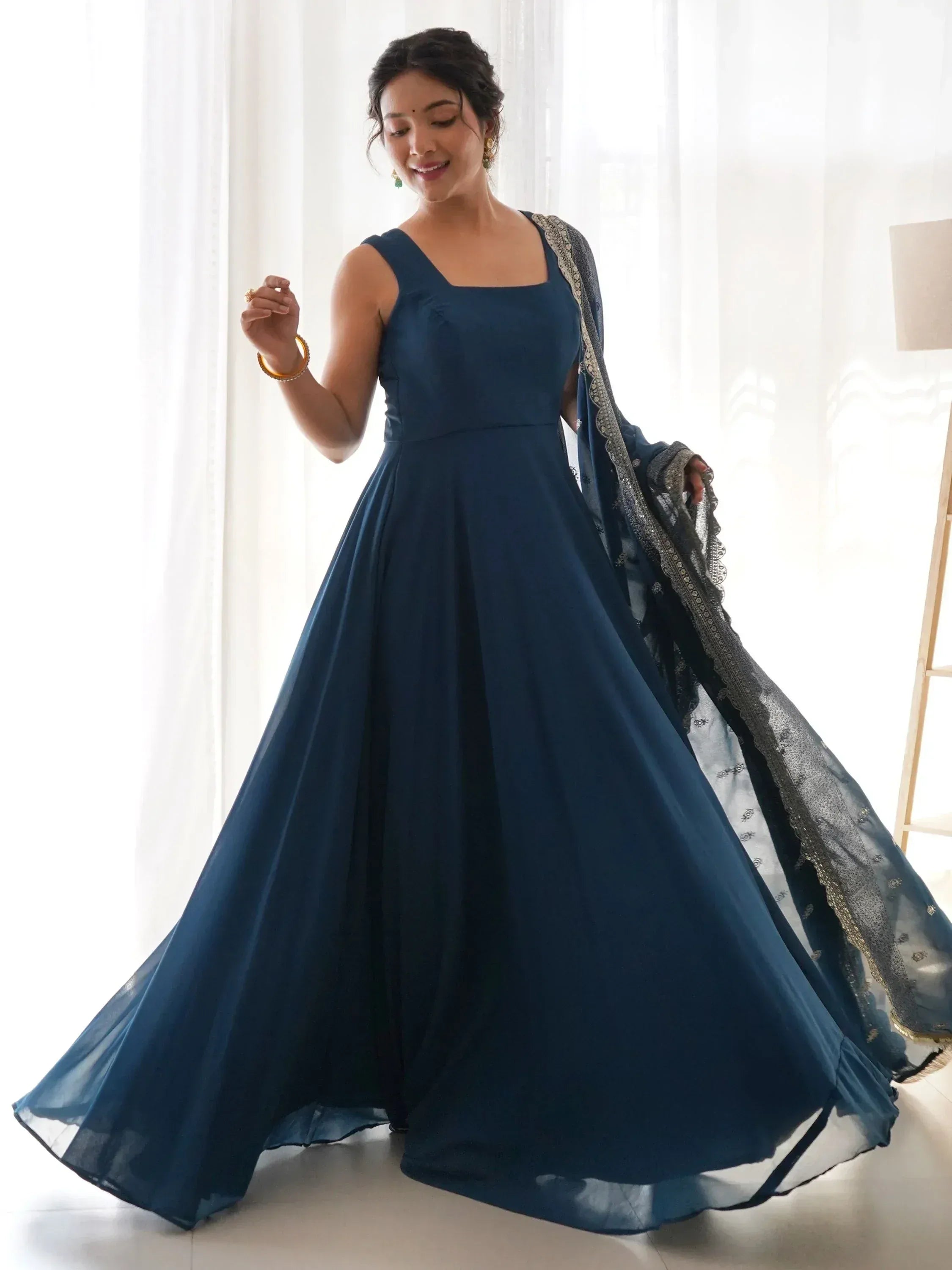Woman in navy blue ethnic gown with embroidered dupatta, perfect for Indian weddings and parties