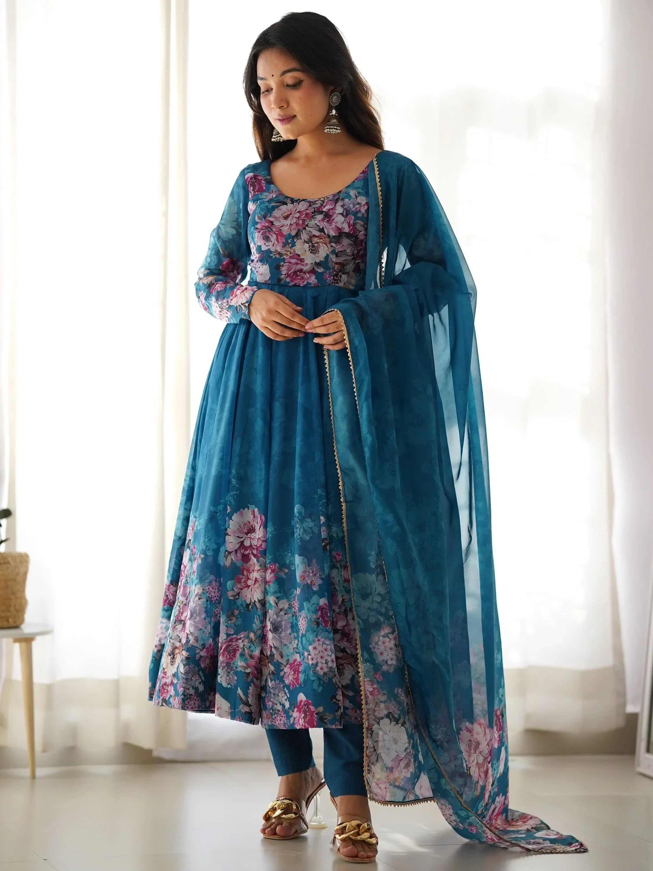 Woman in blue floral Anarkali suit with dupatta, Indian ethnic wear, standing indoors