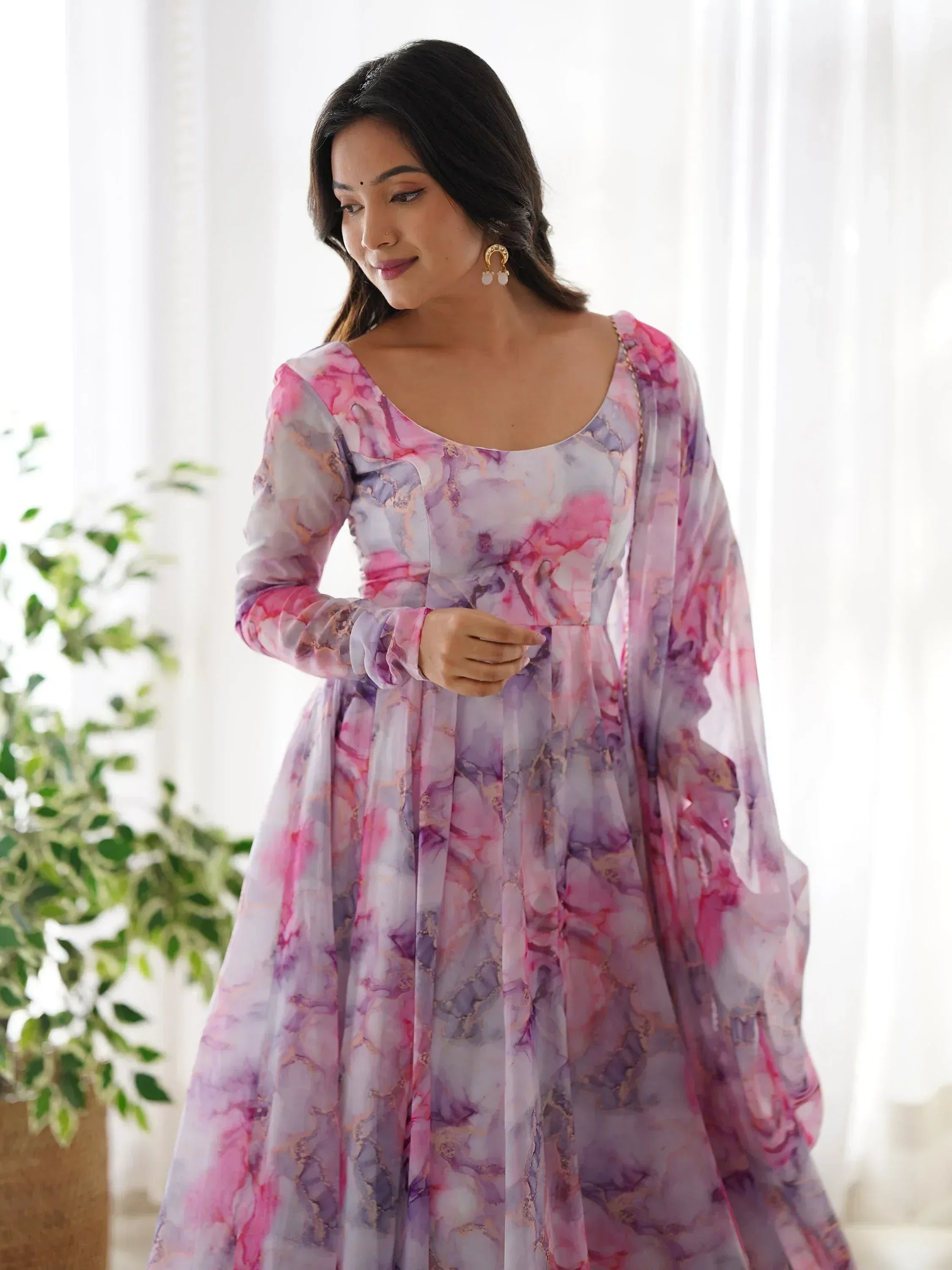 Woman in pink and purple floral ethnic gown with sheer sleeves, perfect for Indian occasions