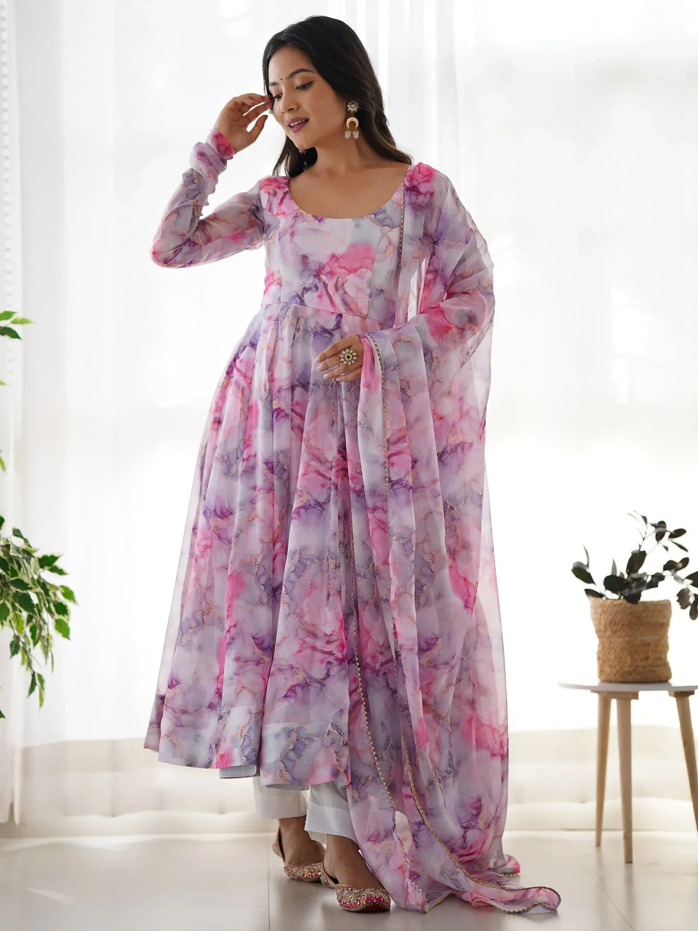 Pink and purple floral print ethnic gown with gold trim, paired with white palazzo pants and embellished flats