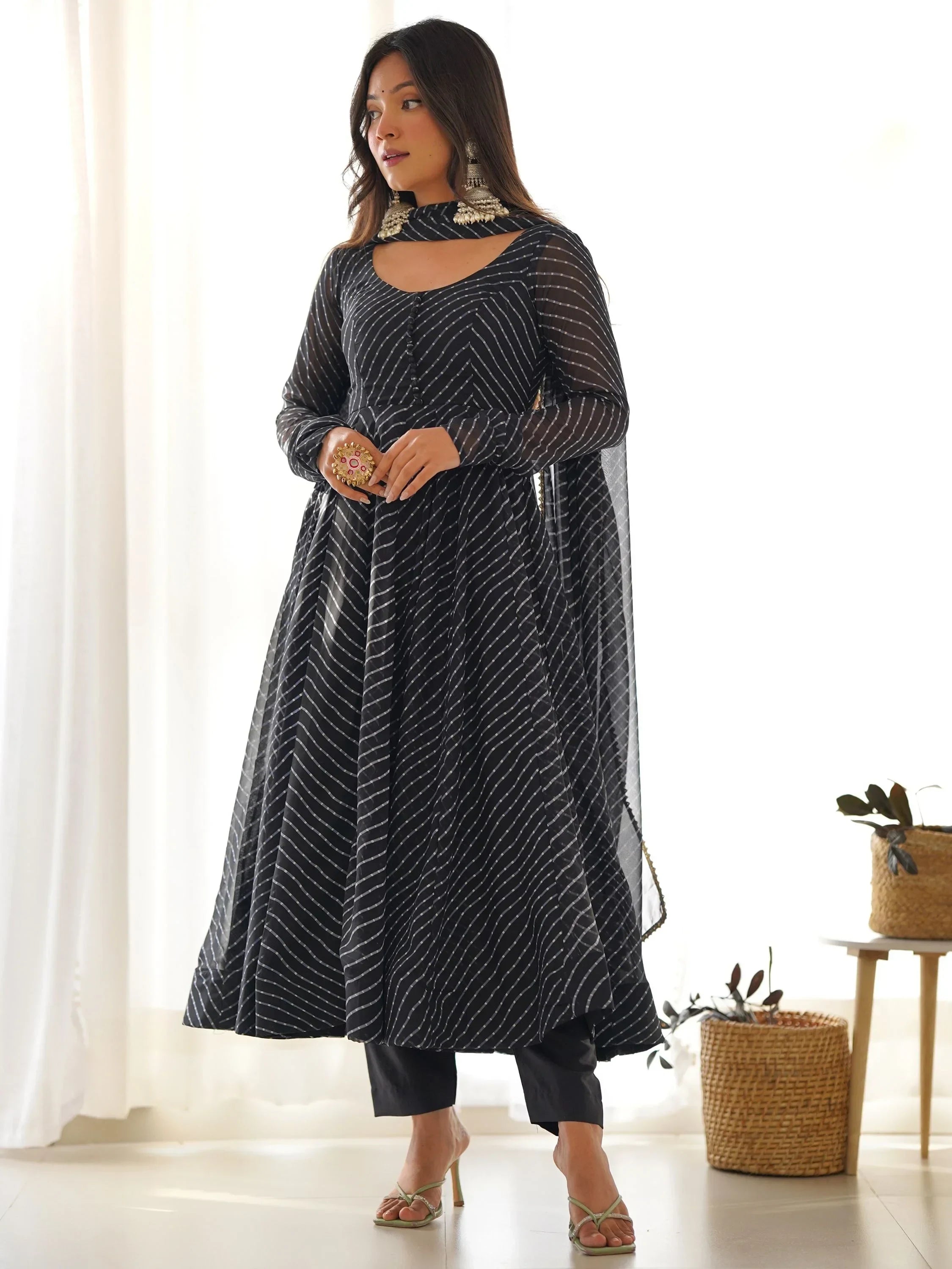 Woman in black striped Anarkali suit with matching dupatta and churidar pants, ethnic jewelry
