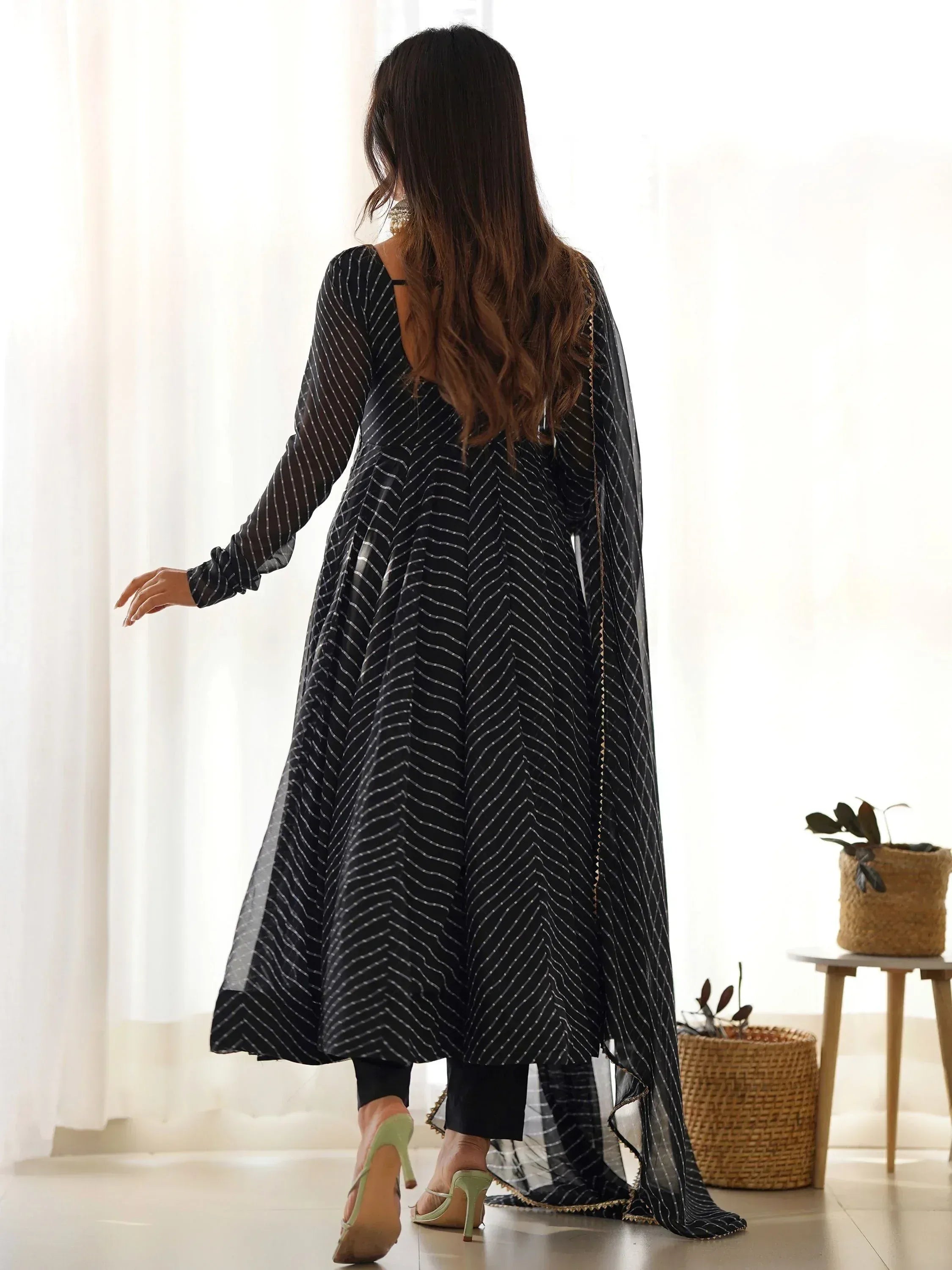 Black and white striped ethnic gown with sheer overlay, styled with palazzo pants and heels for modern Indian wear