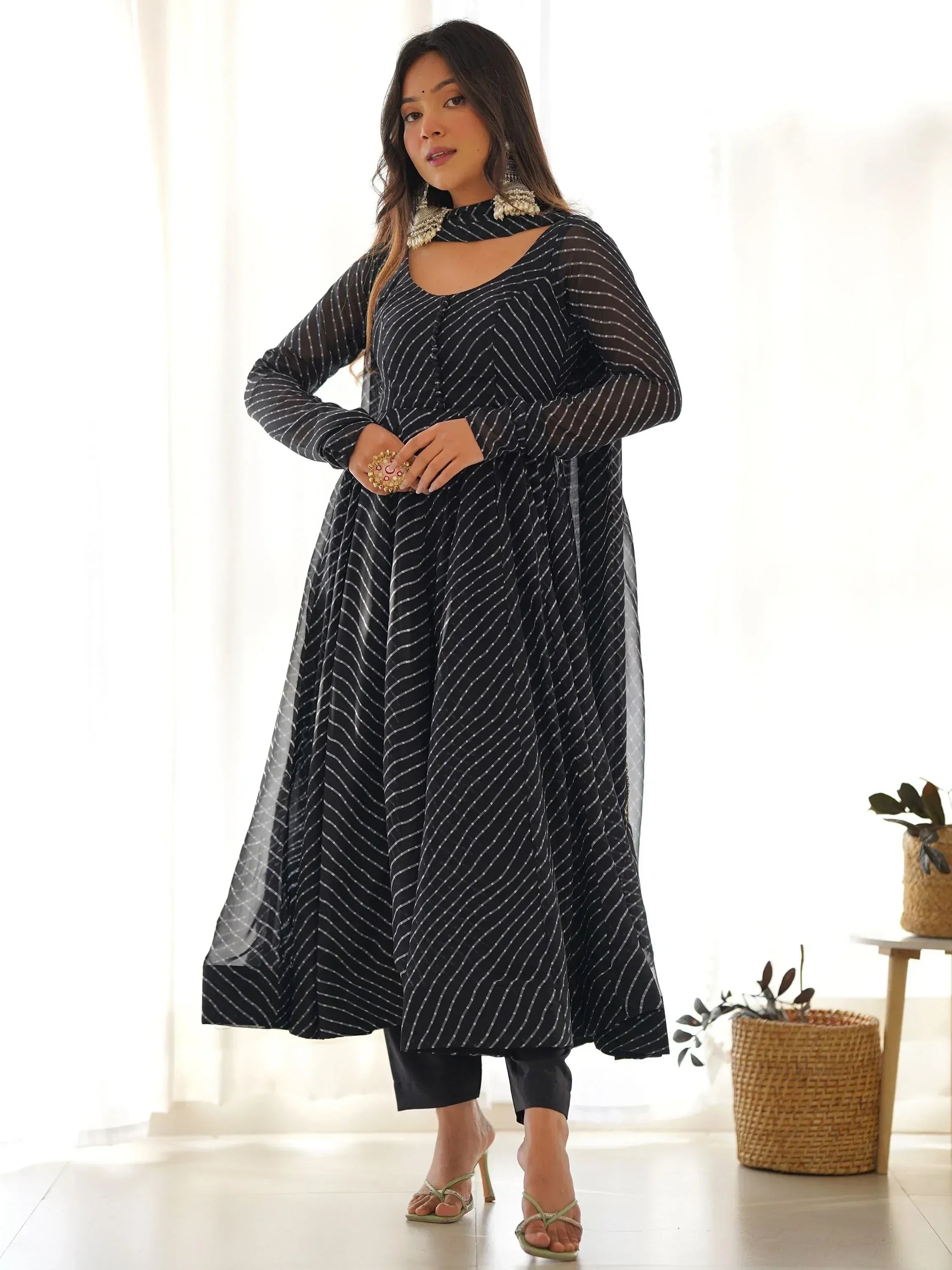 Black and white striped ethnic gown with sheer sleeves and cutout neckline, styled with statement jewelry.