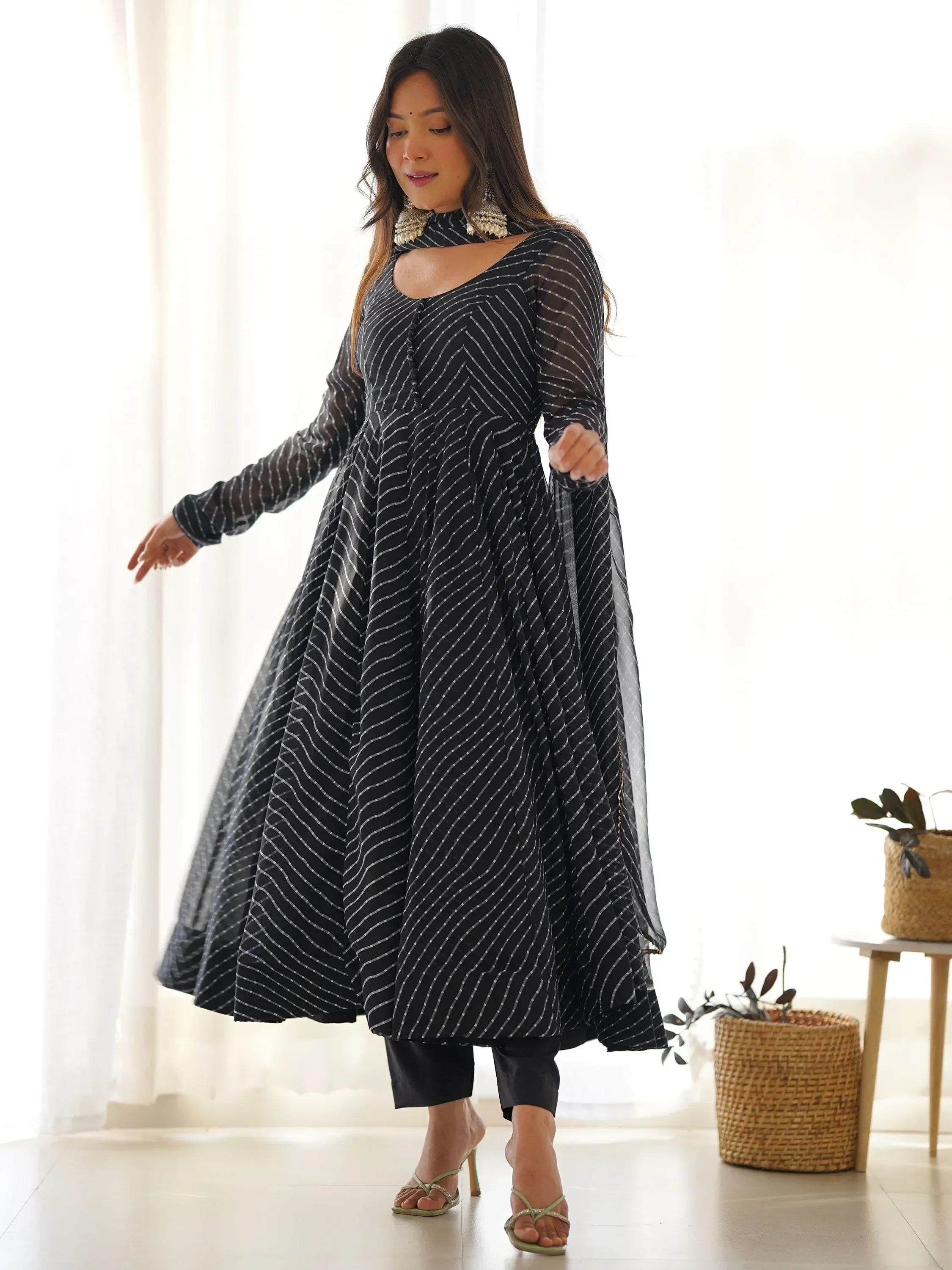 Black and white striped ethnic gown with sheer sleeves, paired with palazzo pants and statement earrings