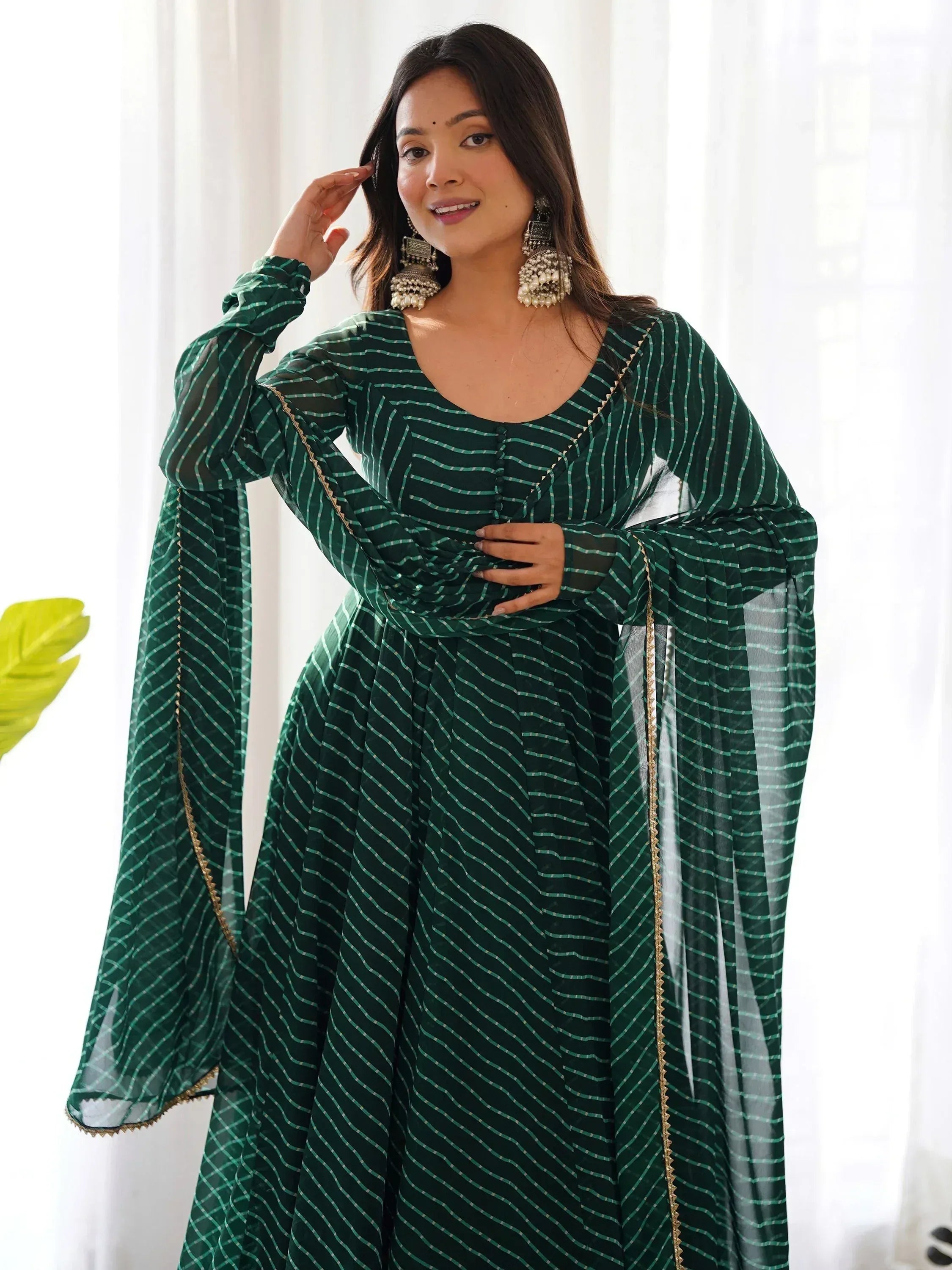 Green striped ethnic gown with bell sleeves and gold trim, perfect for Indian festive occasions.