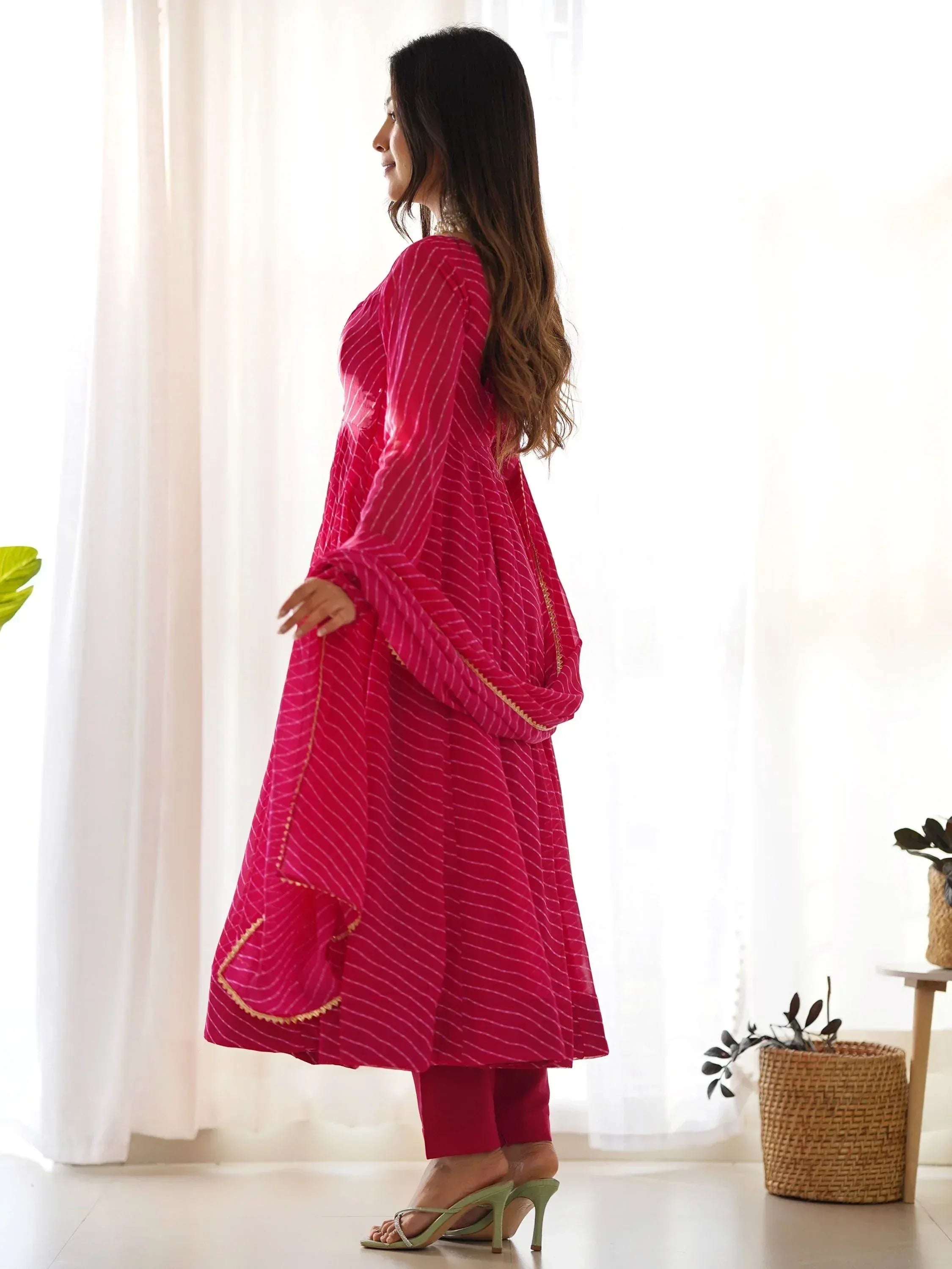 Pink striped ethnic kurta with gold trim, paired with matching pants and green heels, perfect for Indian wear.