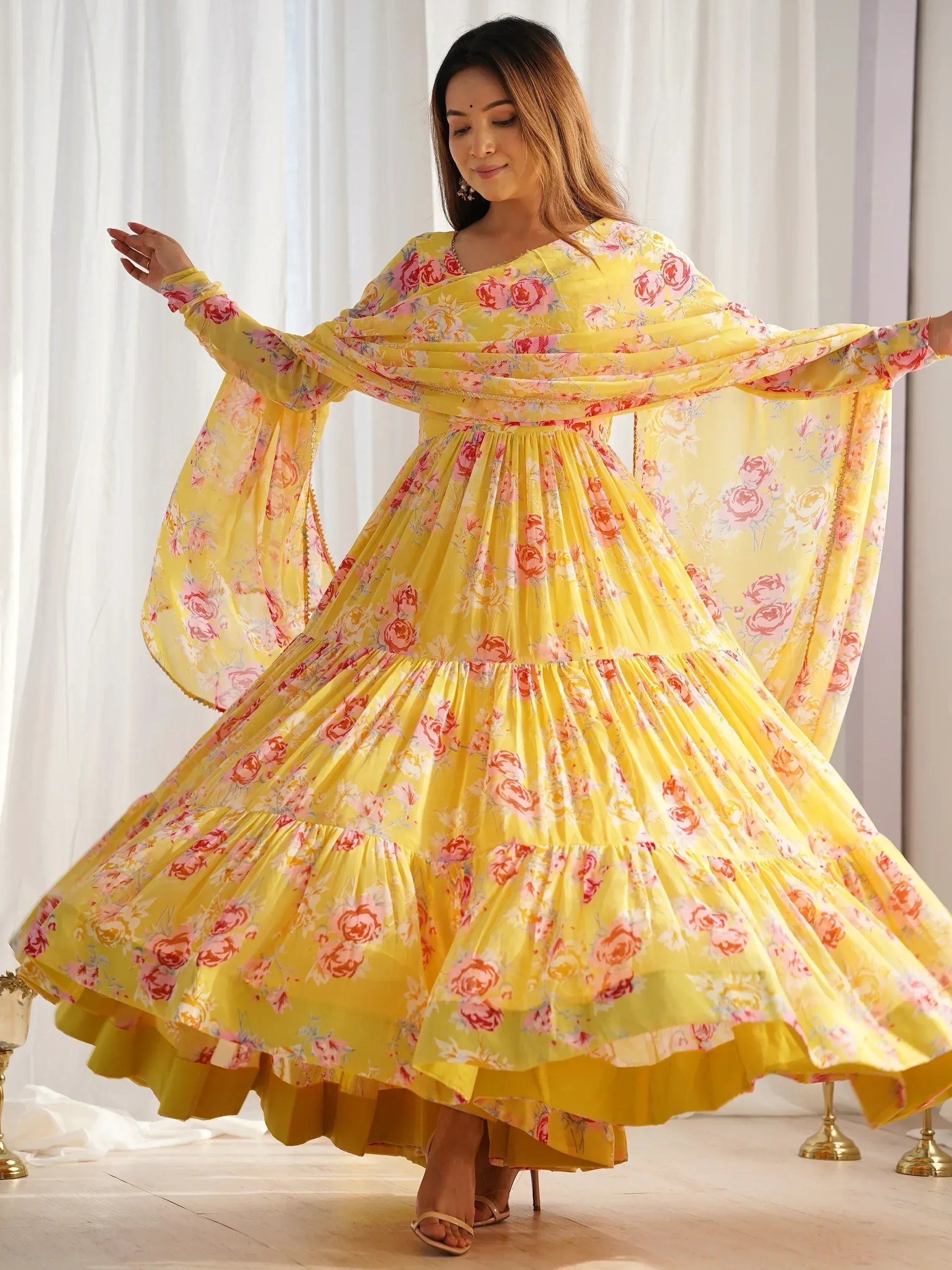 Yellow floral ethnic gown with flared sleeves and tiered skirt, perfect for festive occasions