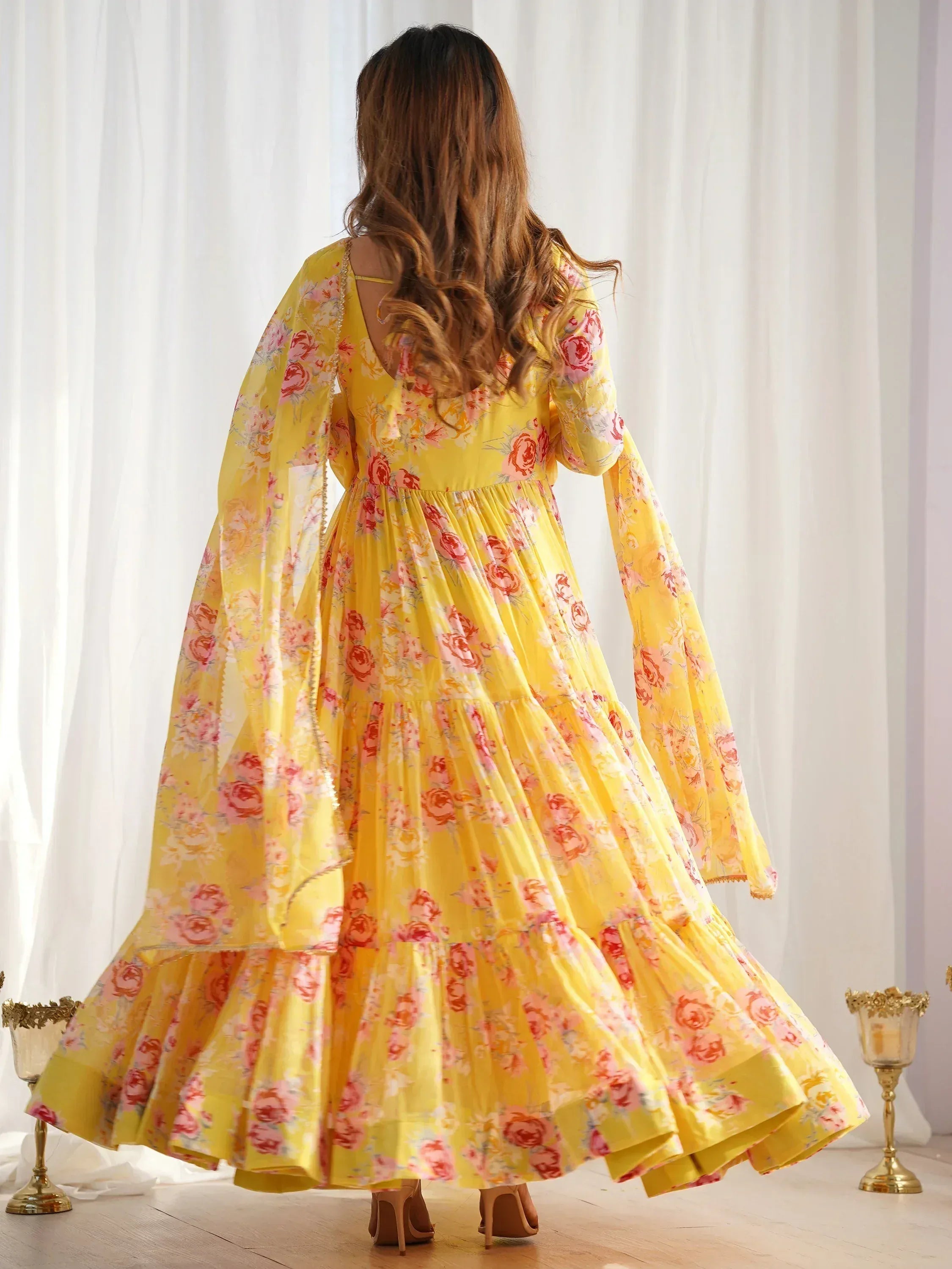 Yellow floral ethnic gown with flared sleeves and tiered skirt, perfect for Indian occasions