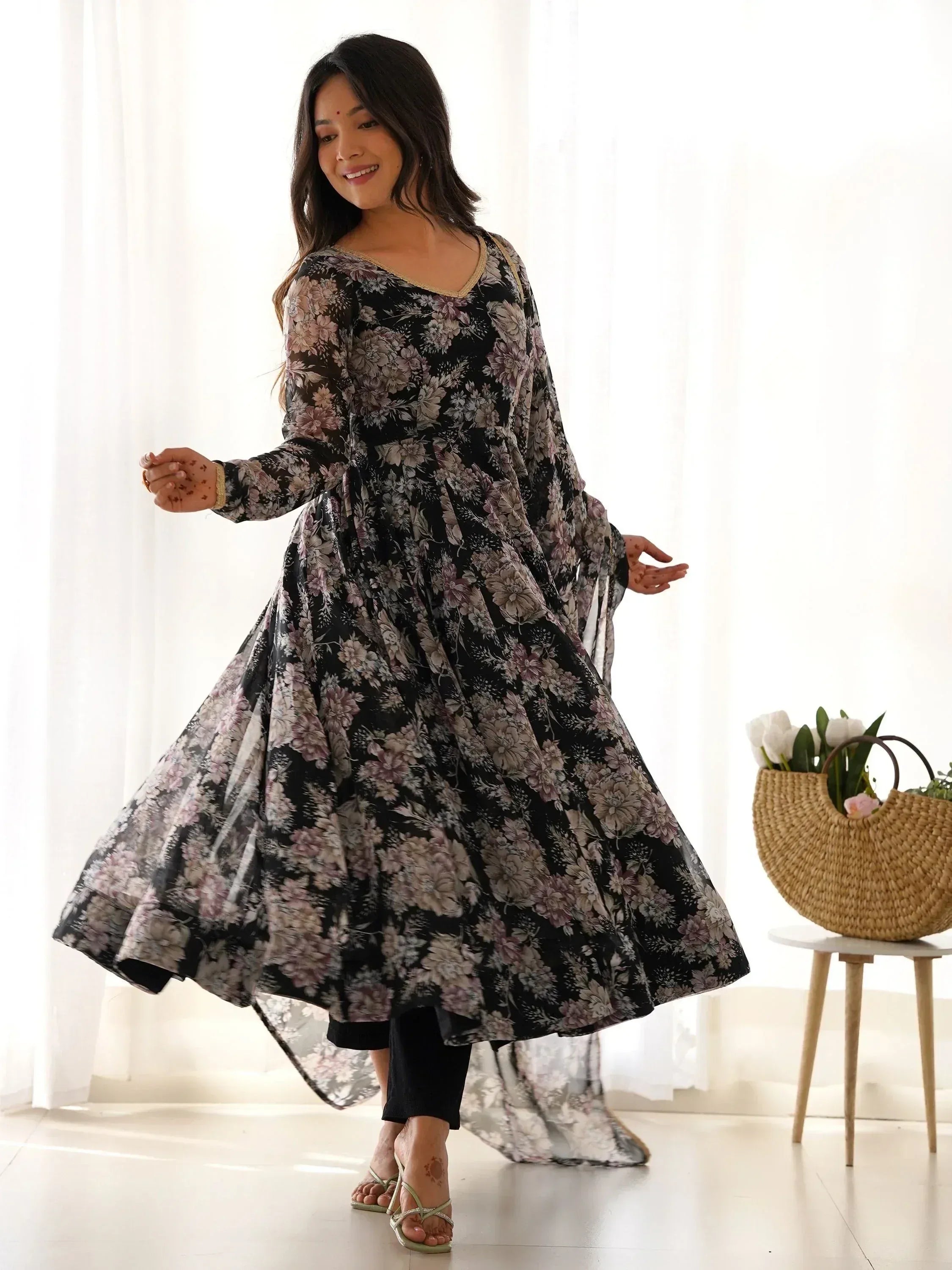 Black floral ethnic gown with gold trim, styled with black pants and sandals for festive occasions