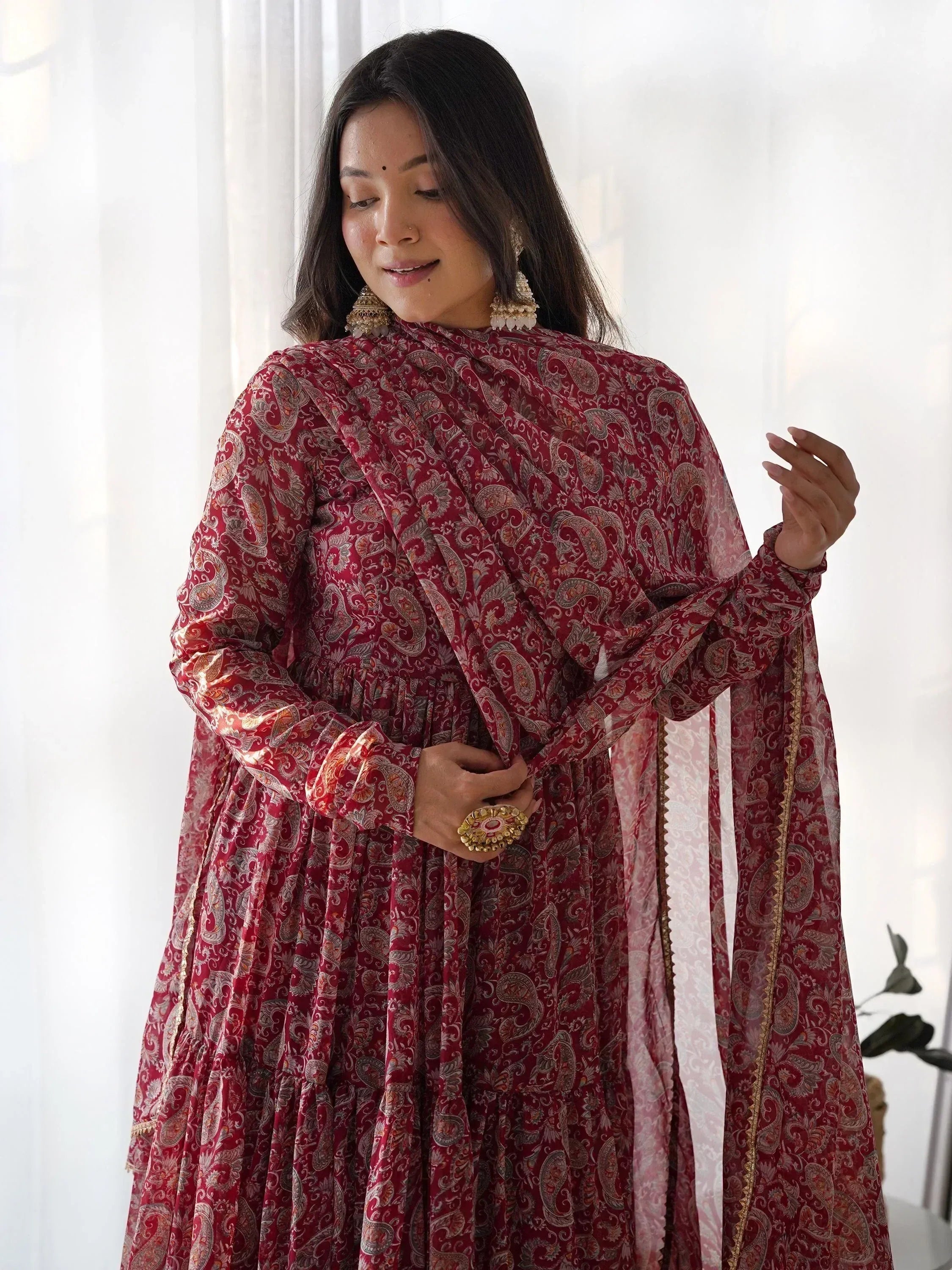Elegant maroon paisley print ethnic gown with gold trim and matching dupatta