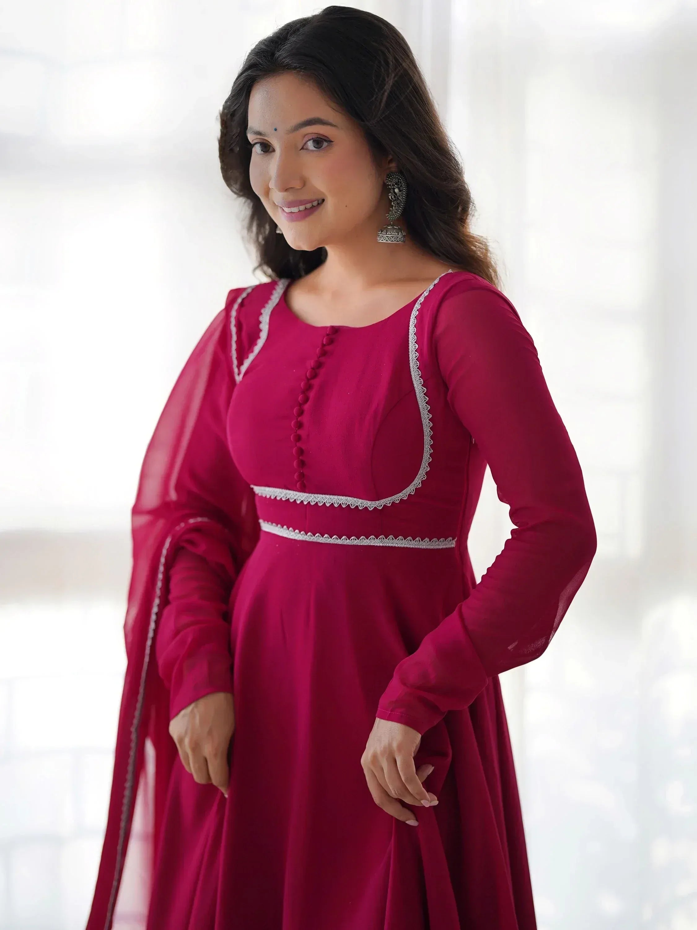 Woman in maroon ethnic gown with white lace detailing, perfect for Indian occasions