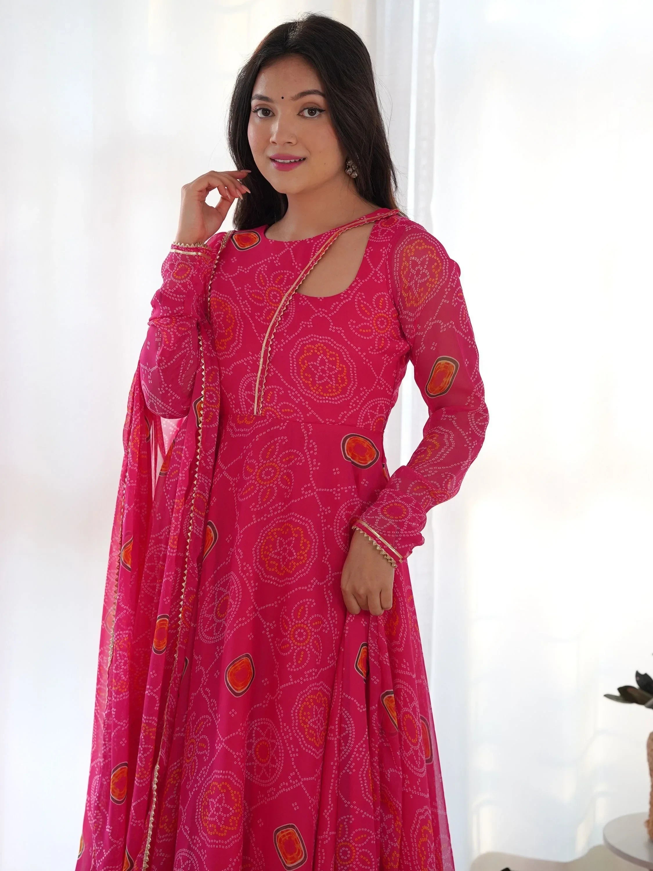 Woman in pink Bandhani print Anarkali dress with long sleeves and dupatta