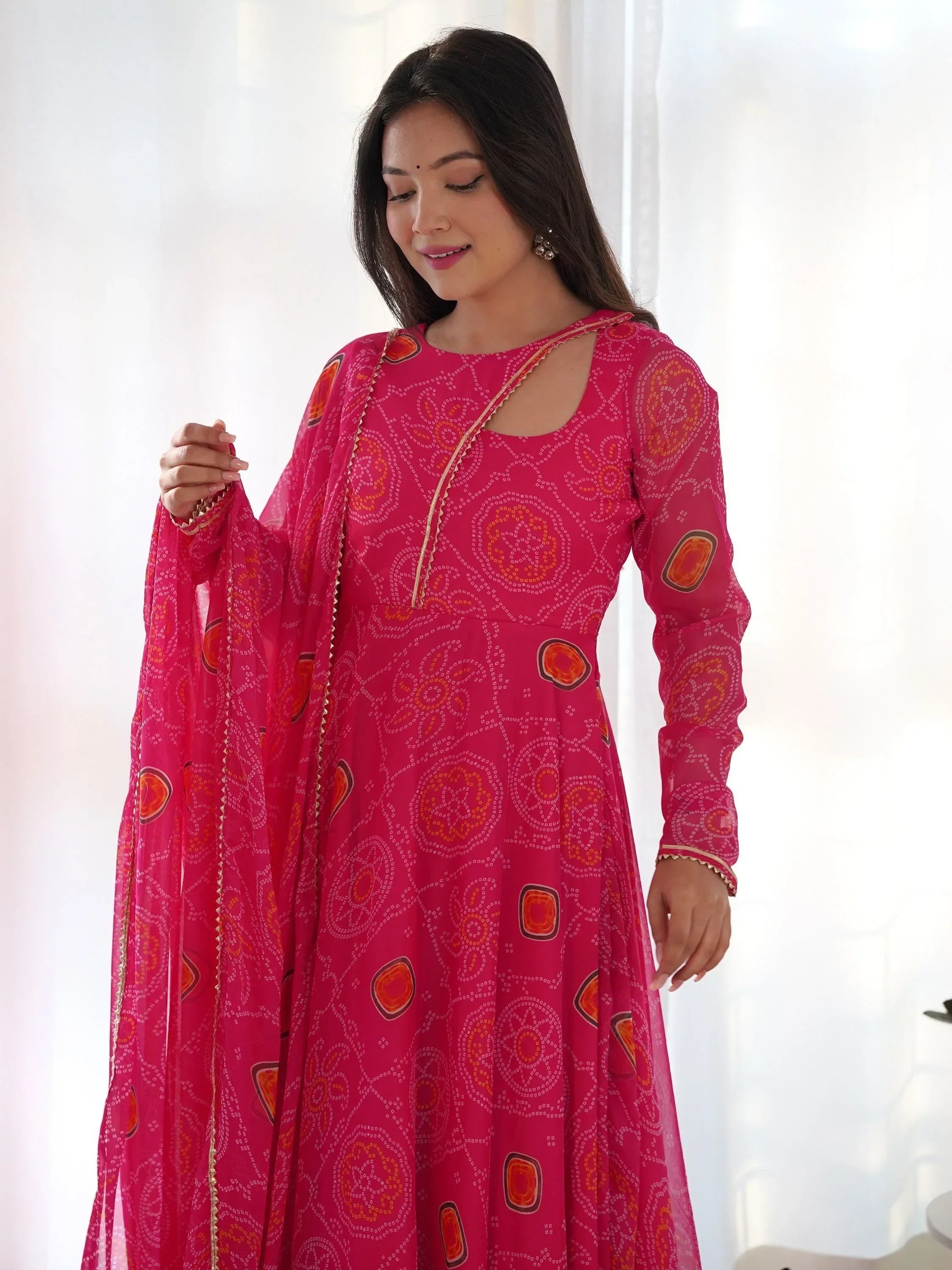 Woman in pink traditional bandhani print ethnic gown with dupatta and cutout neckline
