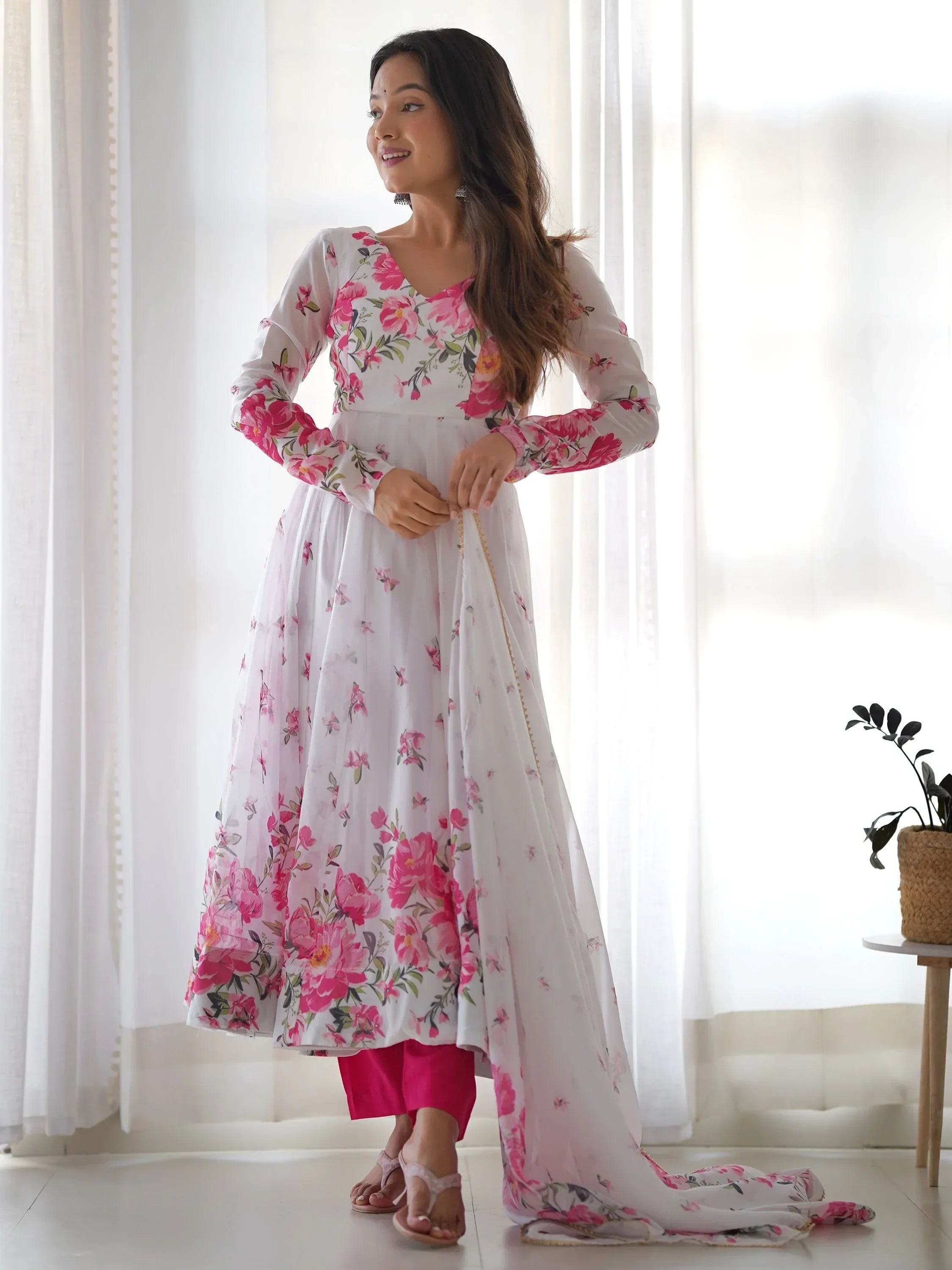 Woman wearing white floral printed ethnic Anarkali suit with pink pants and dupatta