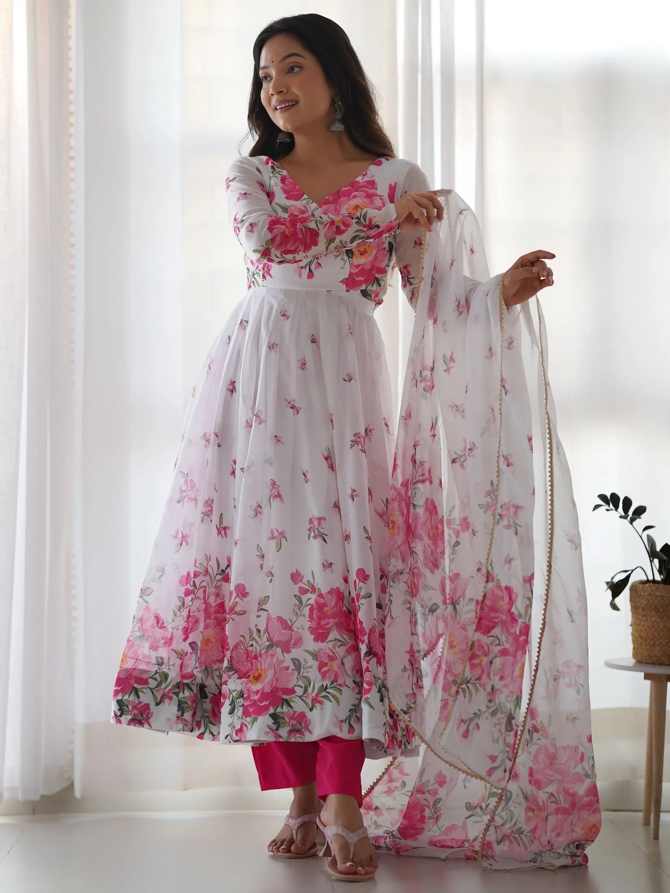 Woman in white floral printed Anarkali suit with pink churidar and dupatta, ethnic wear
