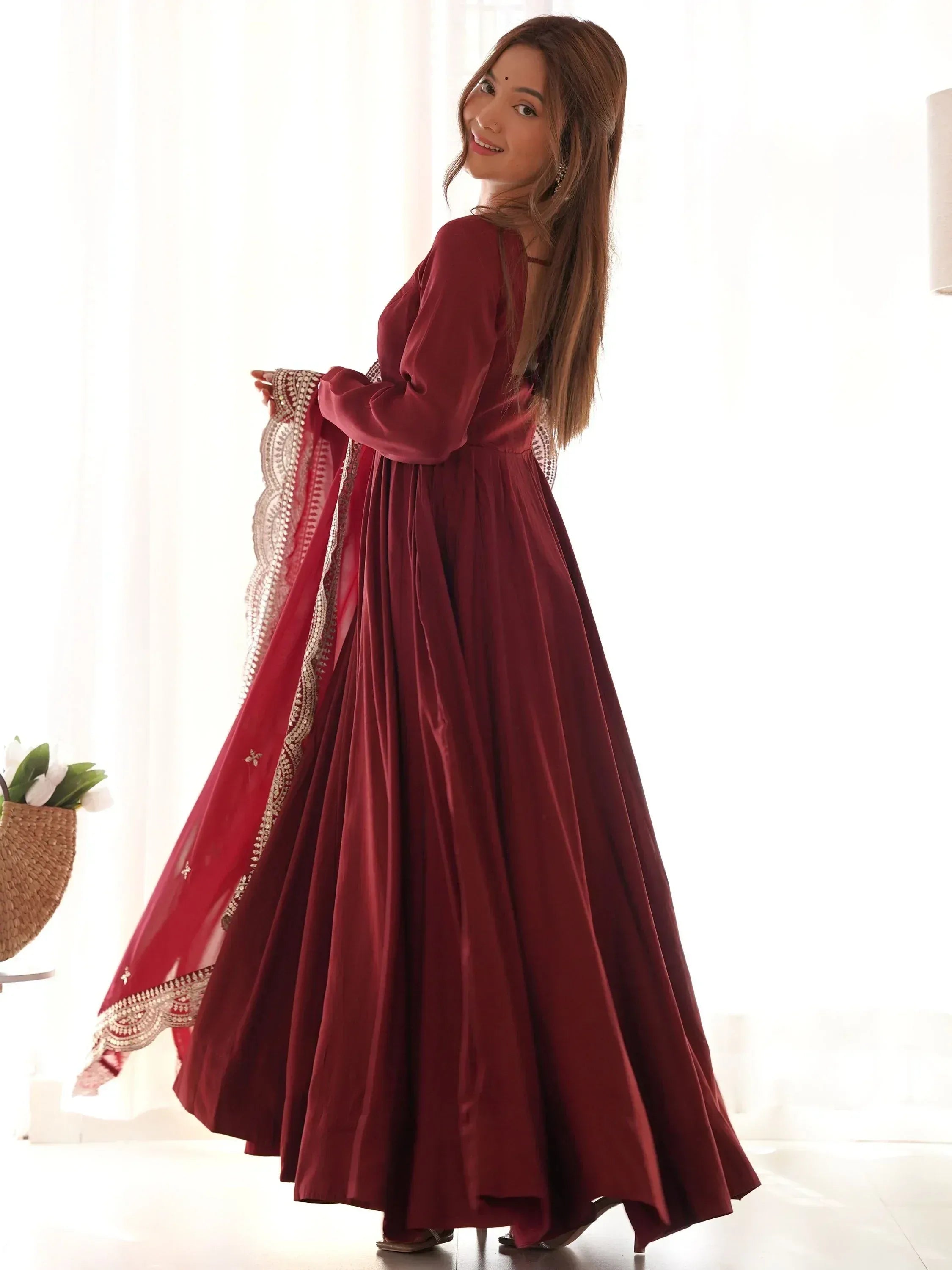 Maroon ethnic gown with gold embroidery, perfect for Indian occasions and festive wear.