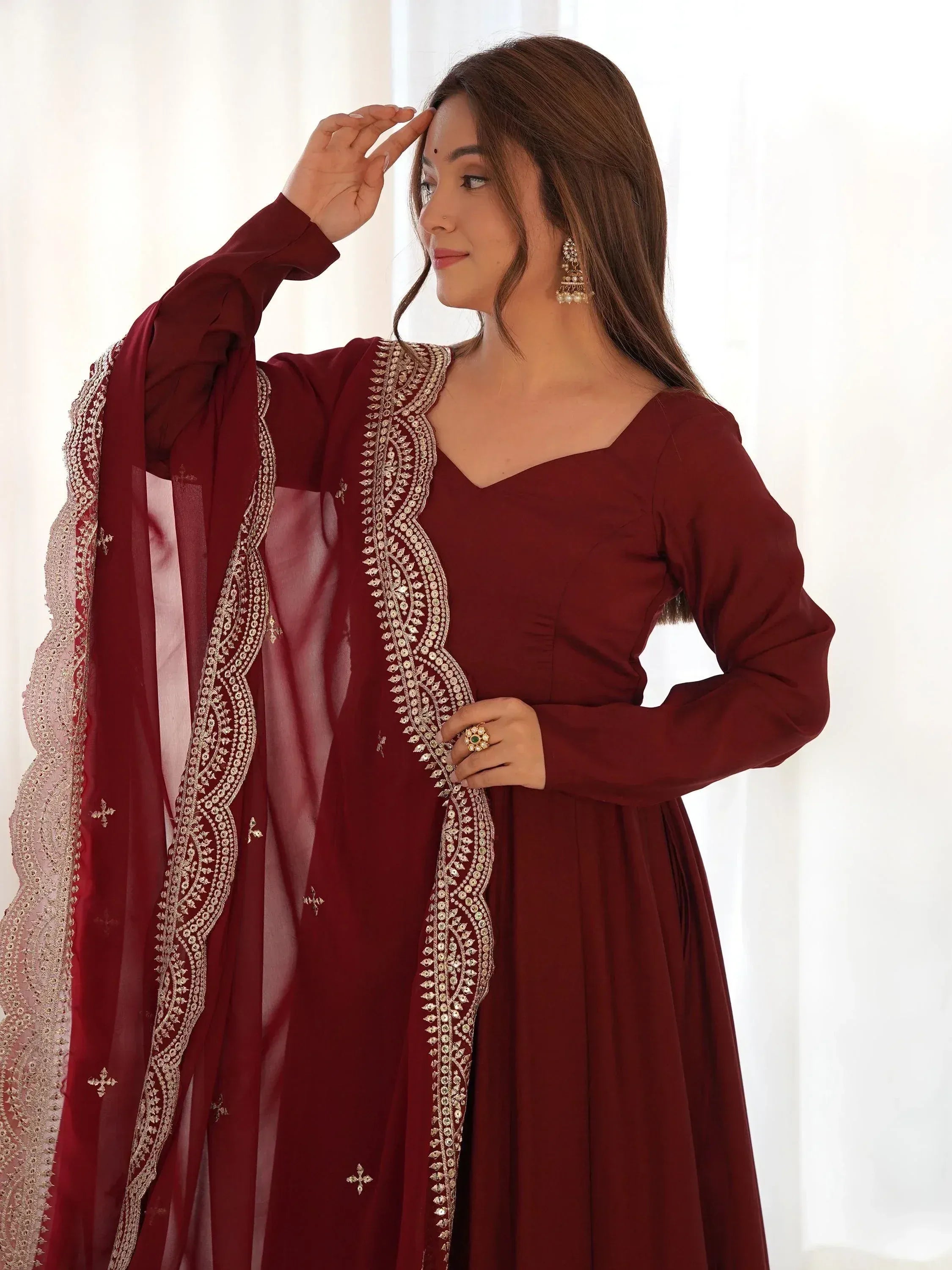 Maroon ethnic gown with gold embroidery, perfect for Indian festive occasions and weddings.