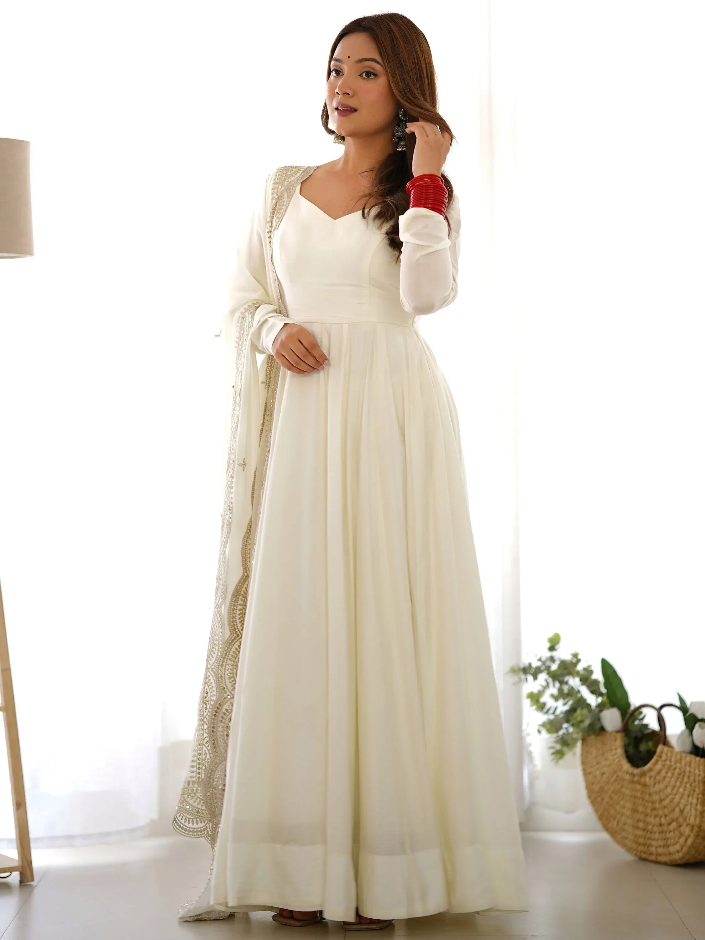 Woman wearing white ethnic gown with dupatta, red bangles, Indian fashion style
