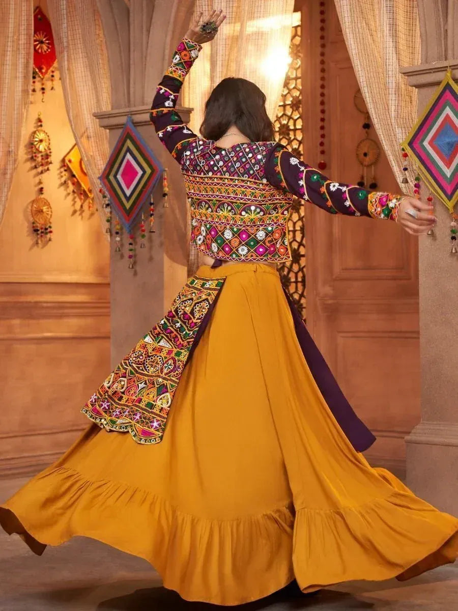 Woman in vibrant Indian ethnic wear, colorful embroidered top with mustard yellow flared skirt, traditional mirror work