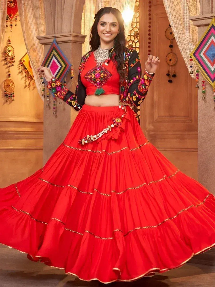 Vibrant red embroidered lehenga choli with mirror work, perfect for Indian ethnic celebrations and festive occasions.