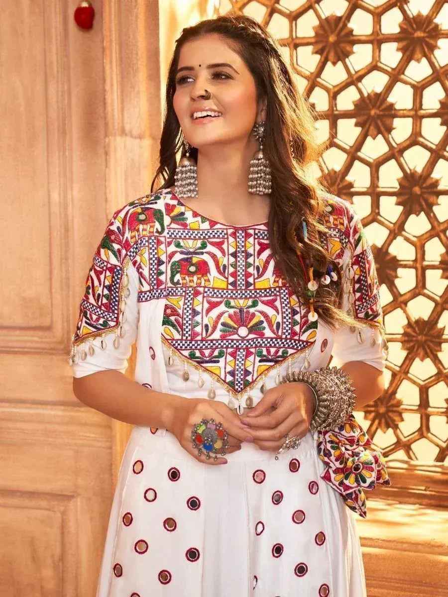 White embroidered ethnic kurti with colorful mirror work and traditional jewelry