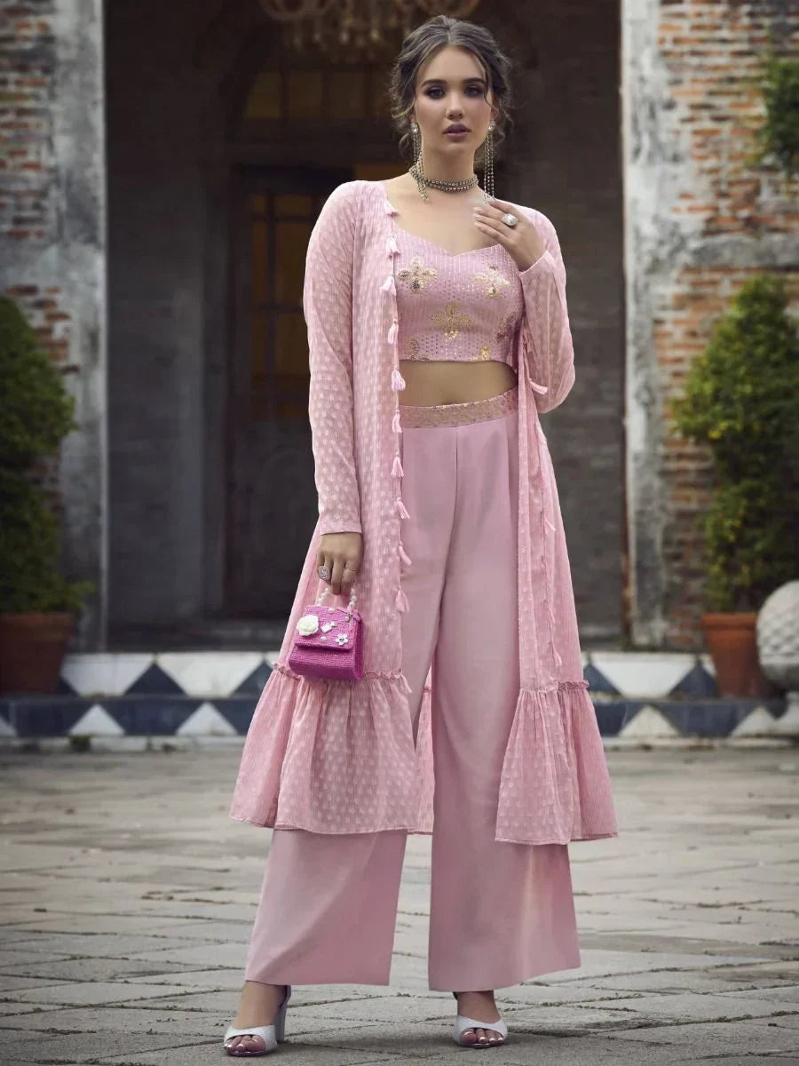 Woman in a pastel pink embroidered crop top, palazzo pants, and long ethnic jacket set