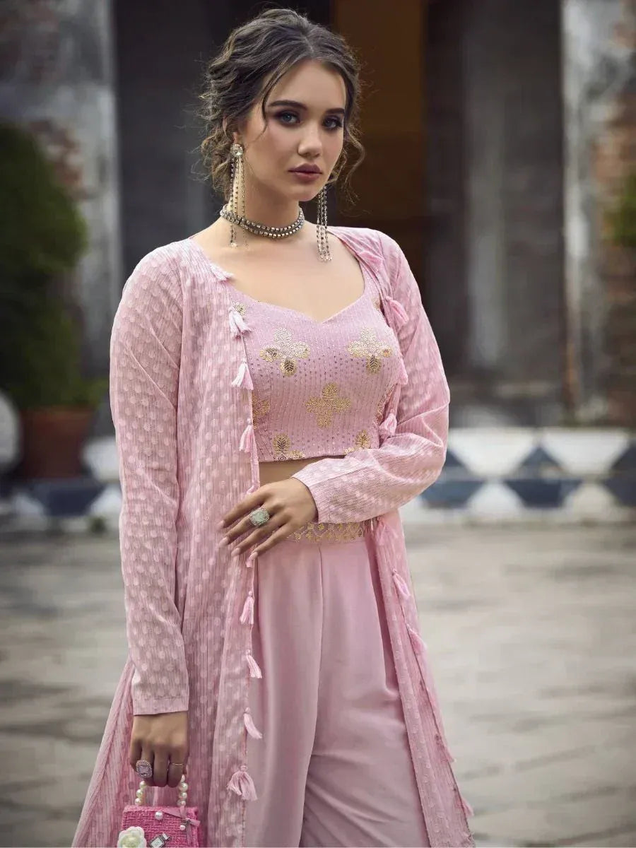 Woman wearing a pink embroidered Indian ethnic palazzo suit with dupatta outdoors