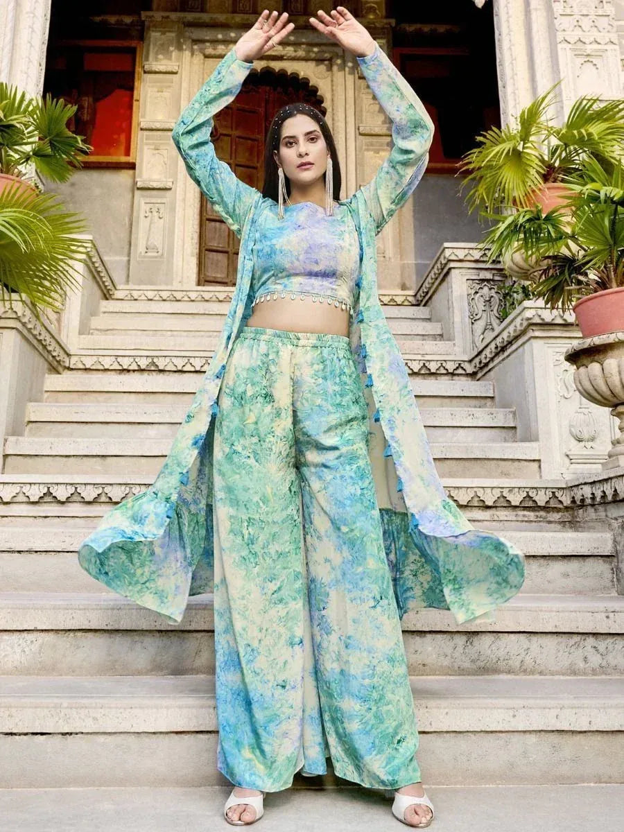 Woman in blue-green tie-dye ethnic palazzo set with long jacket, standing on palace steps