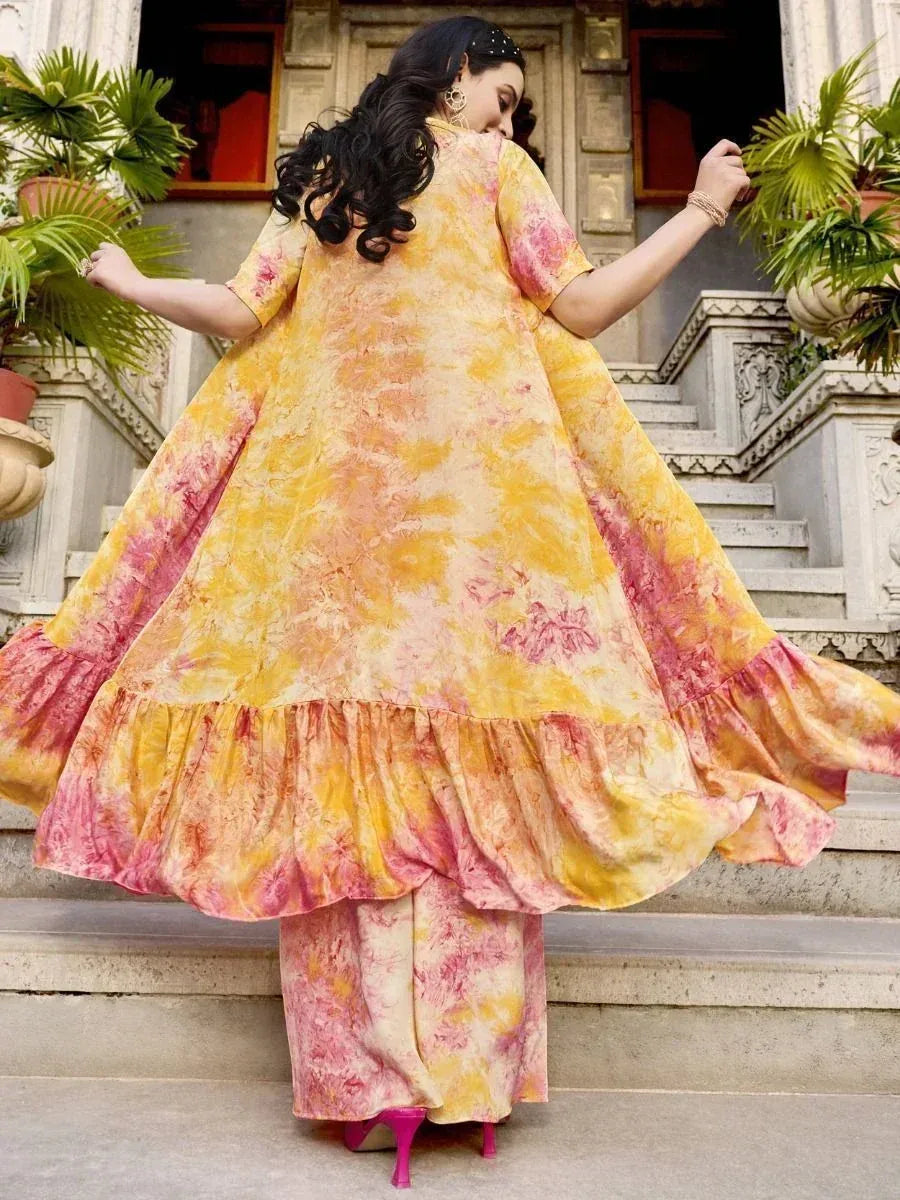 Woman in a yellow and pink tie-dye ethnic gown with ruffle hem, outdoor staircase setting