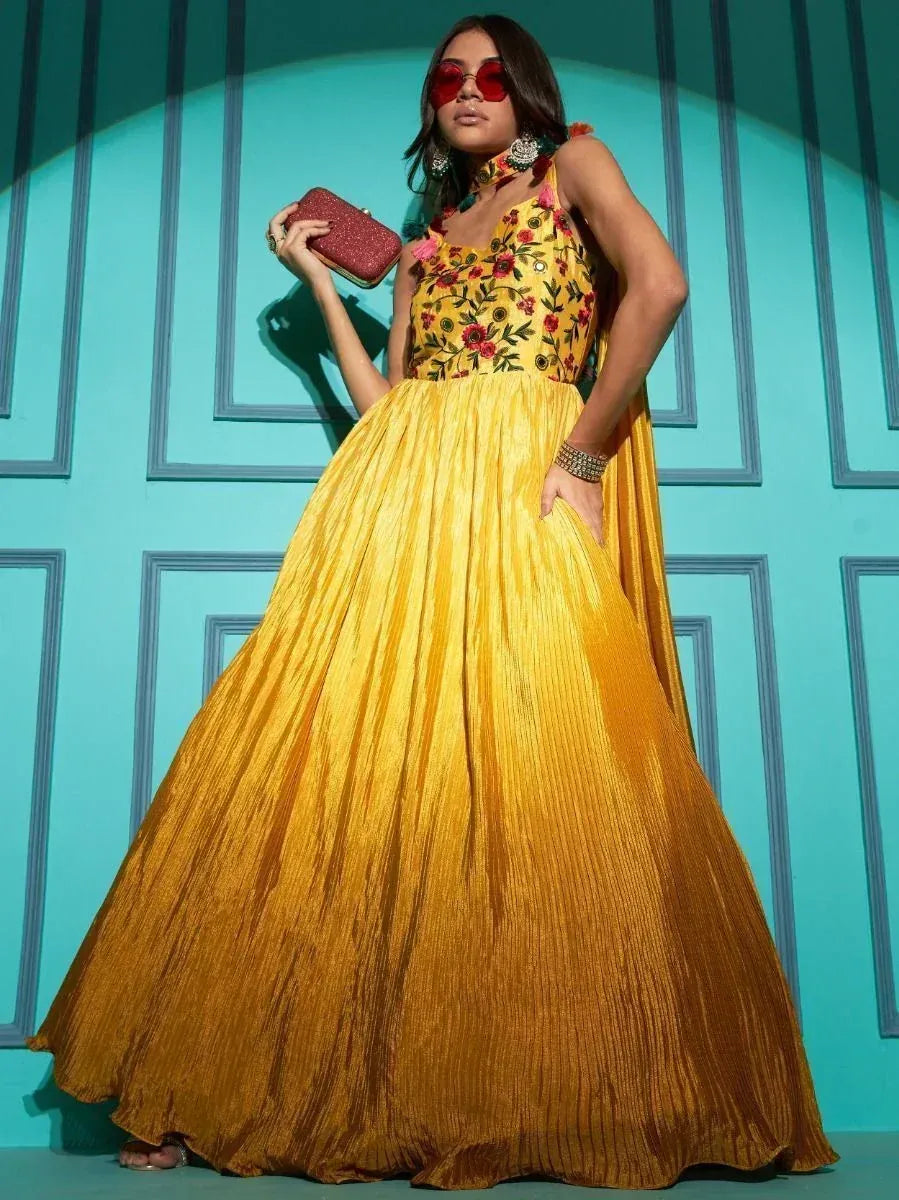 Yellow floral embroidered lehenga choli with pleated skirt, red clutch, and statement jewelry for ethnic wear