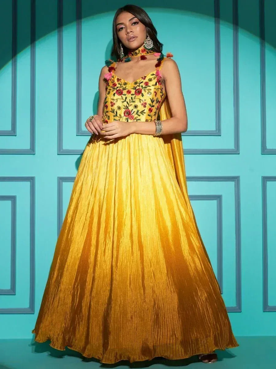 Yellow floral embroidered ethnic gown with pleated skirt, perfect for Indian celebrations and festive occasions.